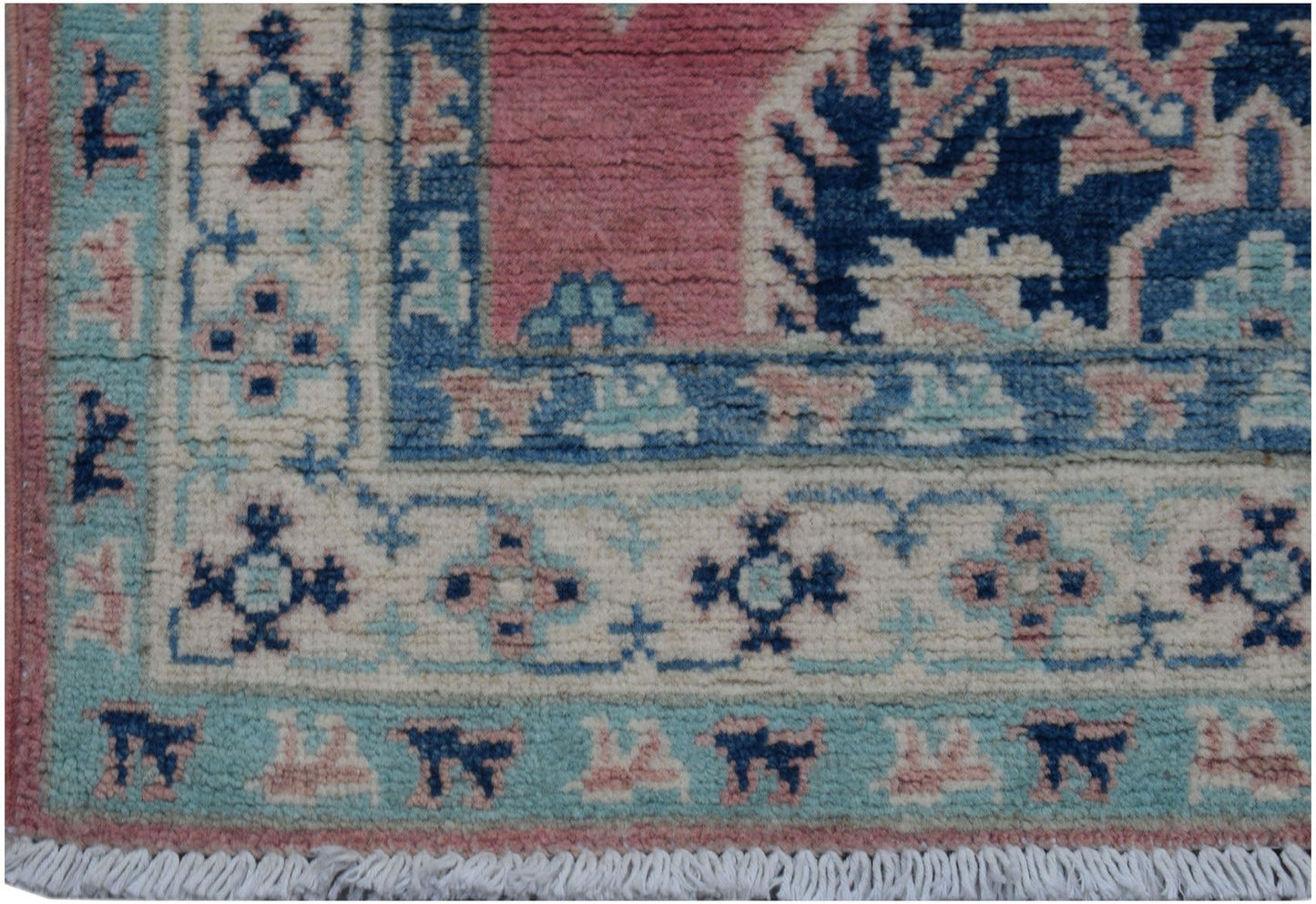 A handmade Afghan Kazakh runner featuring traditional geometric motifs in pink, blue, and cream.