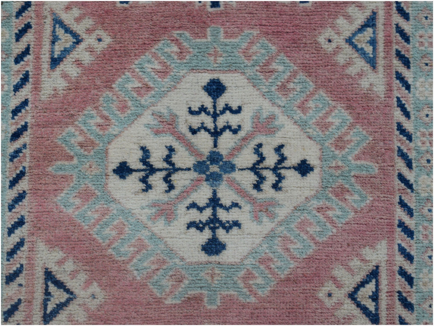Handmade Afghan Kazakh runner featuring a central floral medallion in blue, pink, and cream wool.