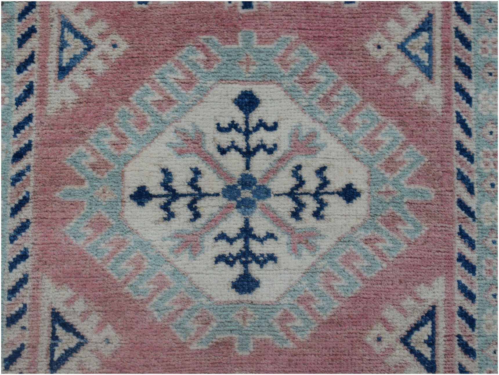 Handmade Afghan Kazakh runner featuring a central floral medallion in blue, pink, and cream wool.