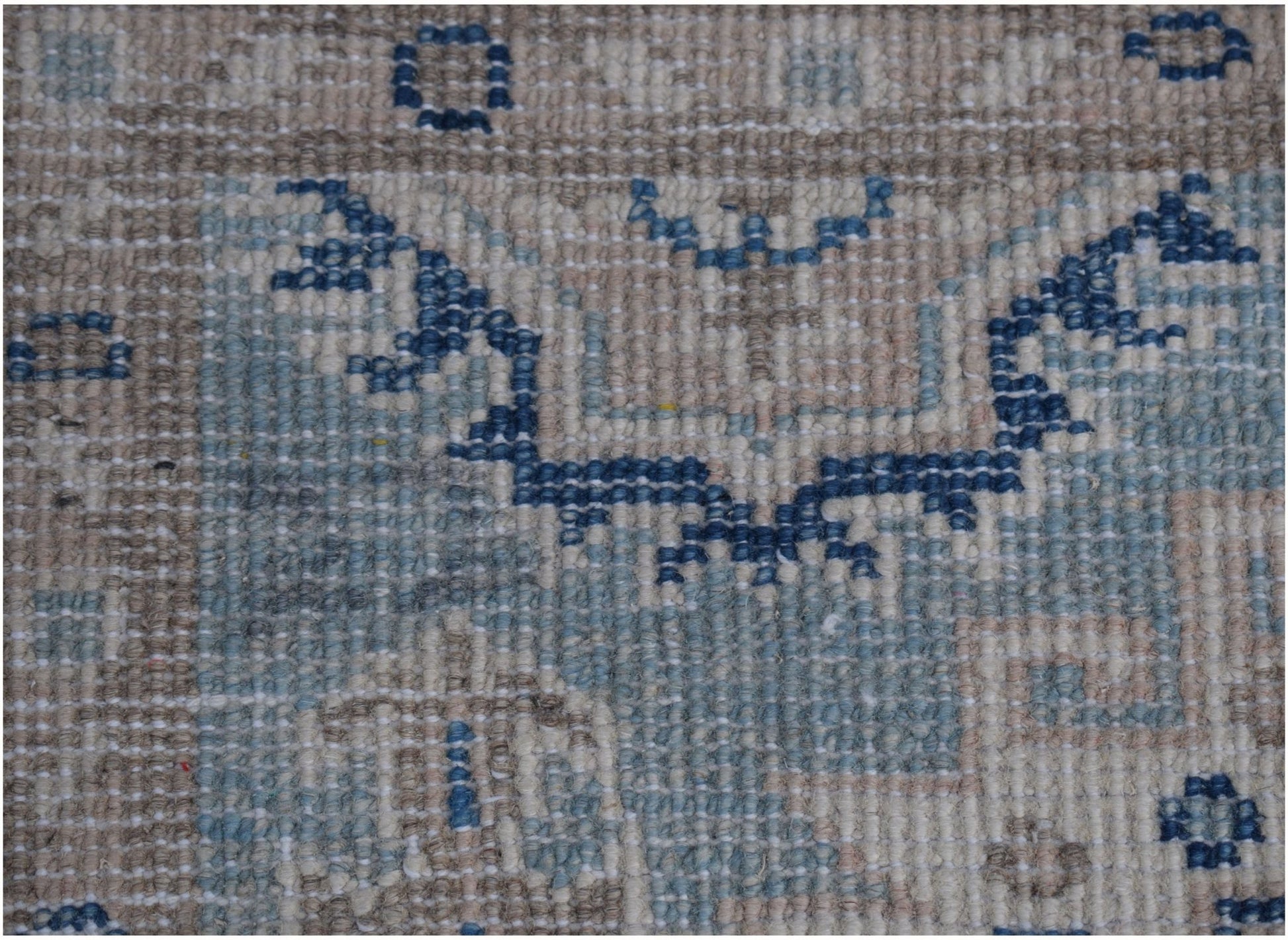 A handmade Afghan Kazakh runner rug featuring a geometric pattern in shades of blue, beige, and grey.