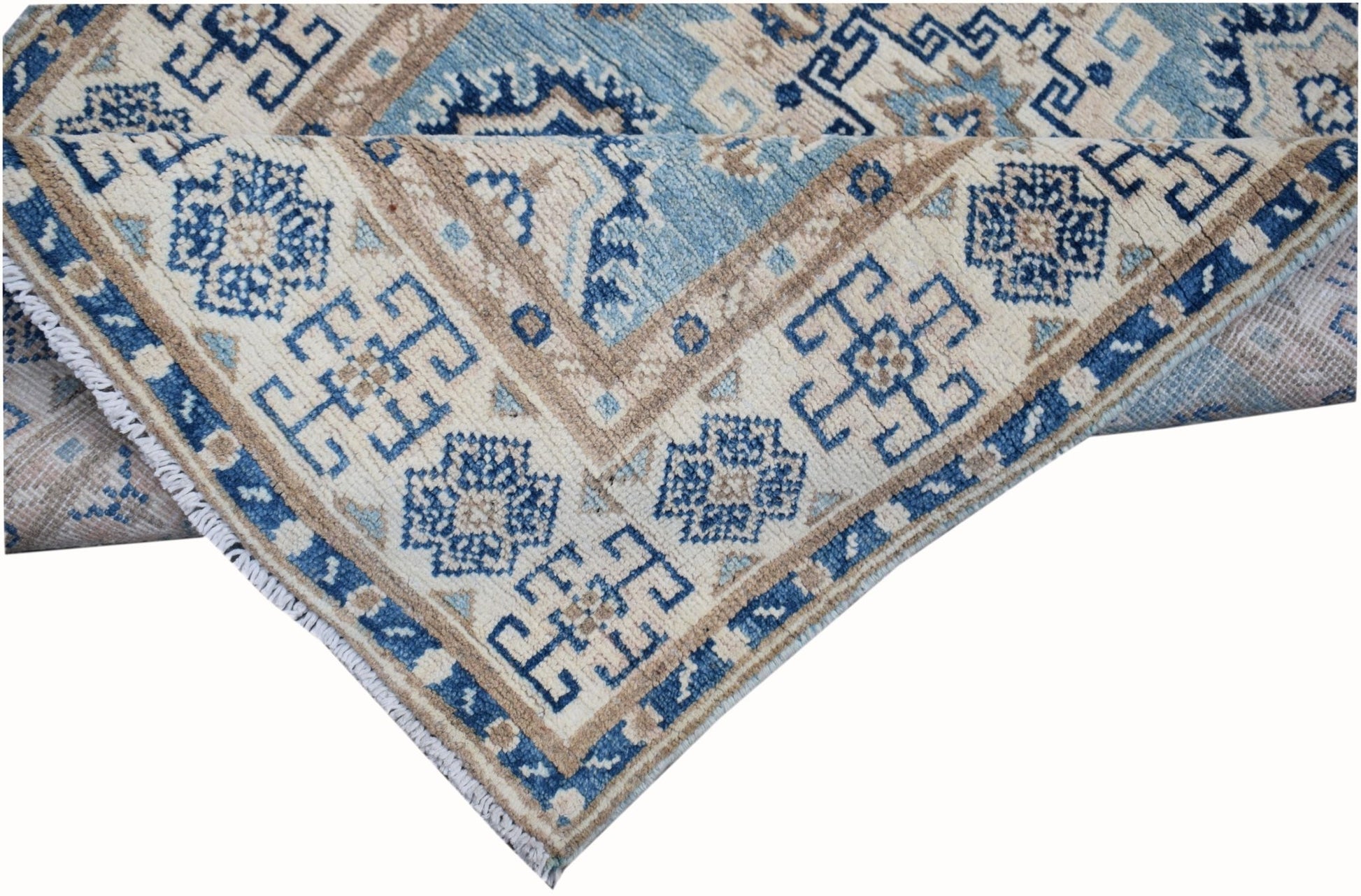 An Afghan Kazakh runner rug featuring a geometric pattern in shades of blue, beige, and grey.