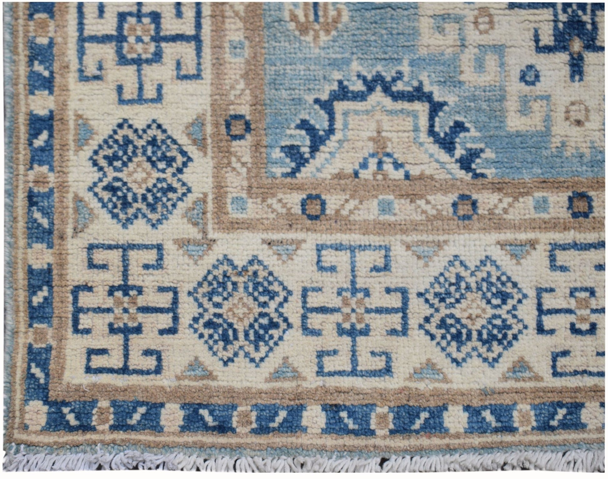 Handmade Afghan Kazakh runner rug featuring geometric blue and beige patterns on a cream field.