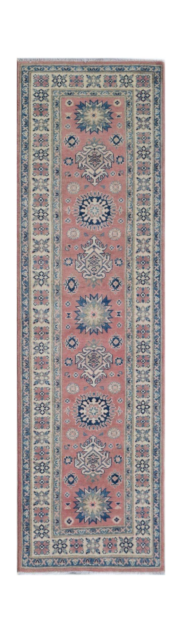 A handmade Afghan Kazakh runner rug featuring traditional geometric motifs in pink and blue.