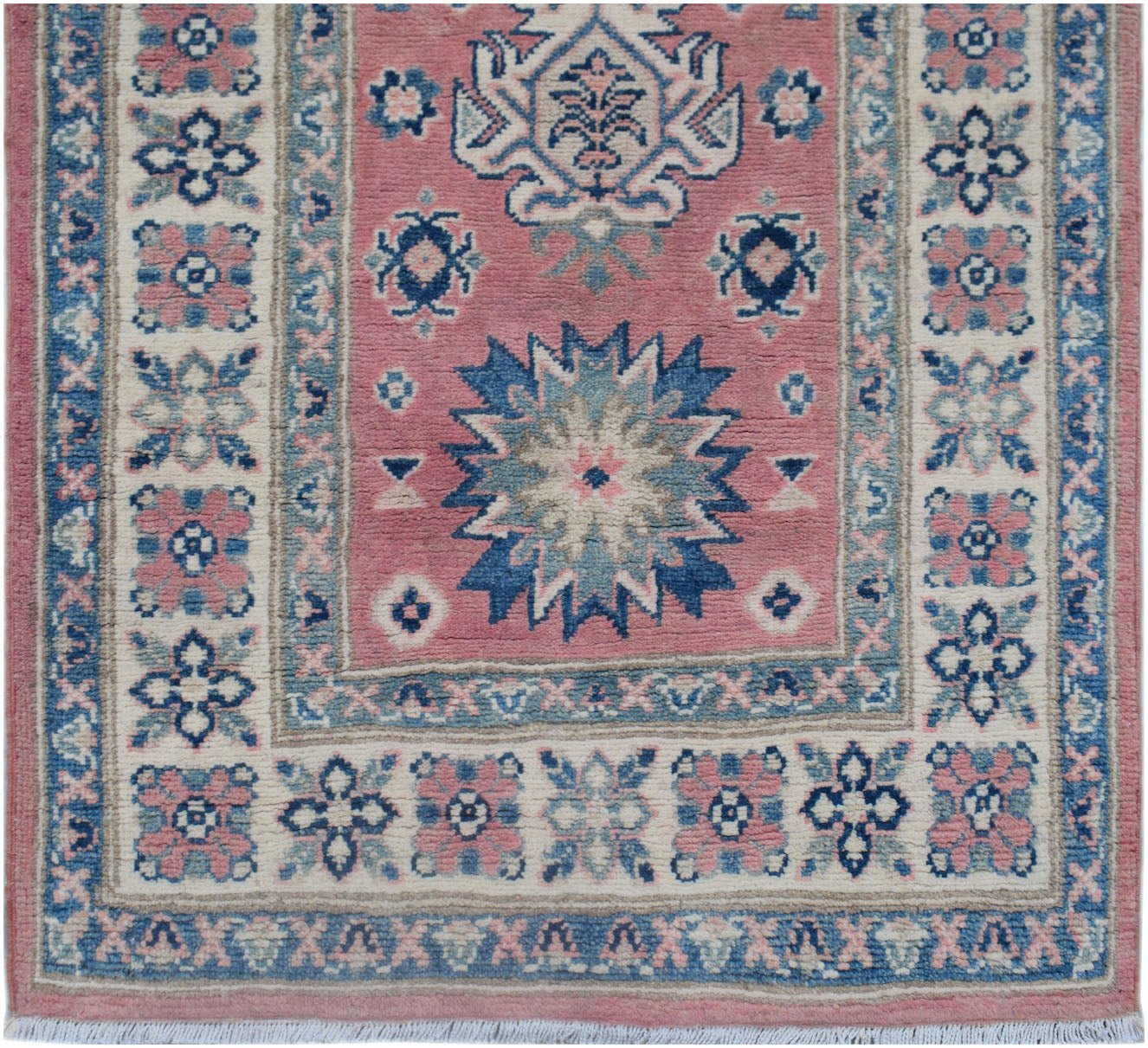 Handmade Afghan Kazakh runner featuring a pink field with blue geometric floral motifs.
