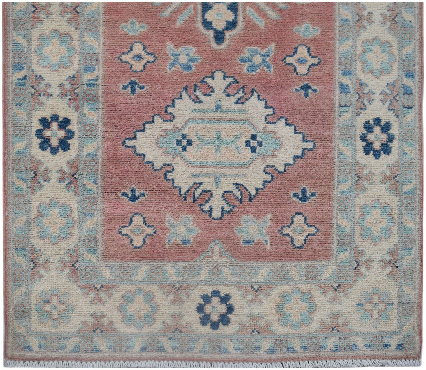 Handmade Afghan Kazakh runner featuring a central medallion on a dusty rose field with floral motifs.