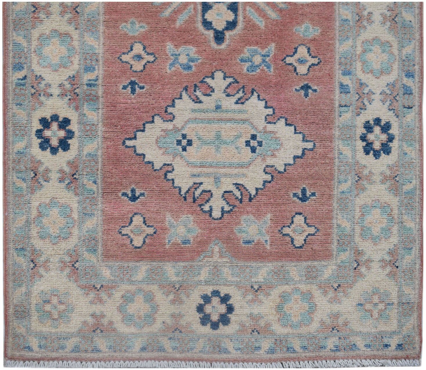 Handmade Afghan Kazakh runner featuring a central medallion on a dusty rose field with floral motifs.