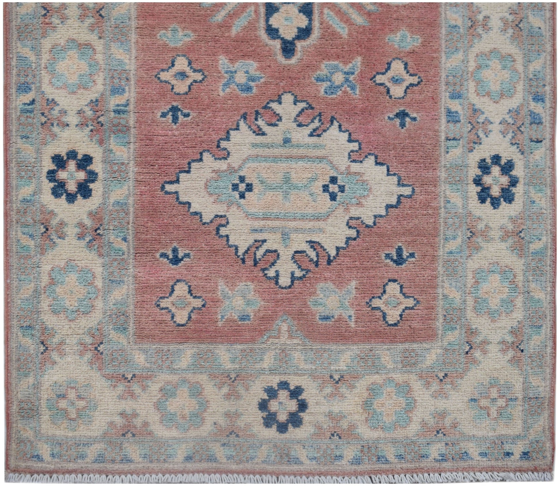 Handmade Afghan Kazakh runner featuring a central geometric medallion on a dusty pink field.