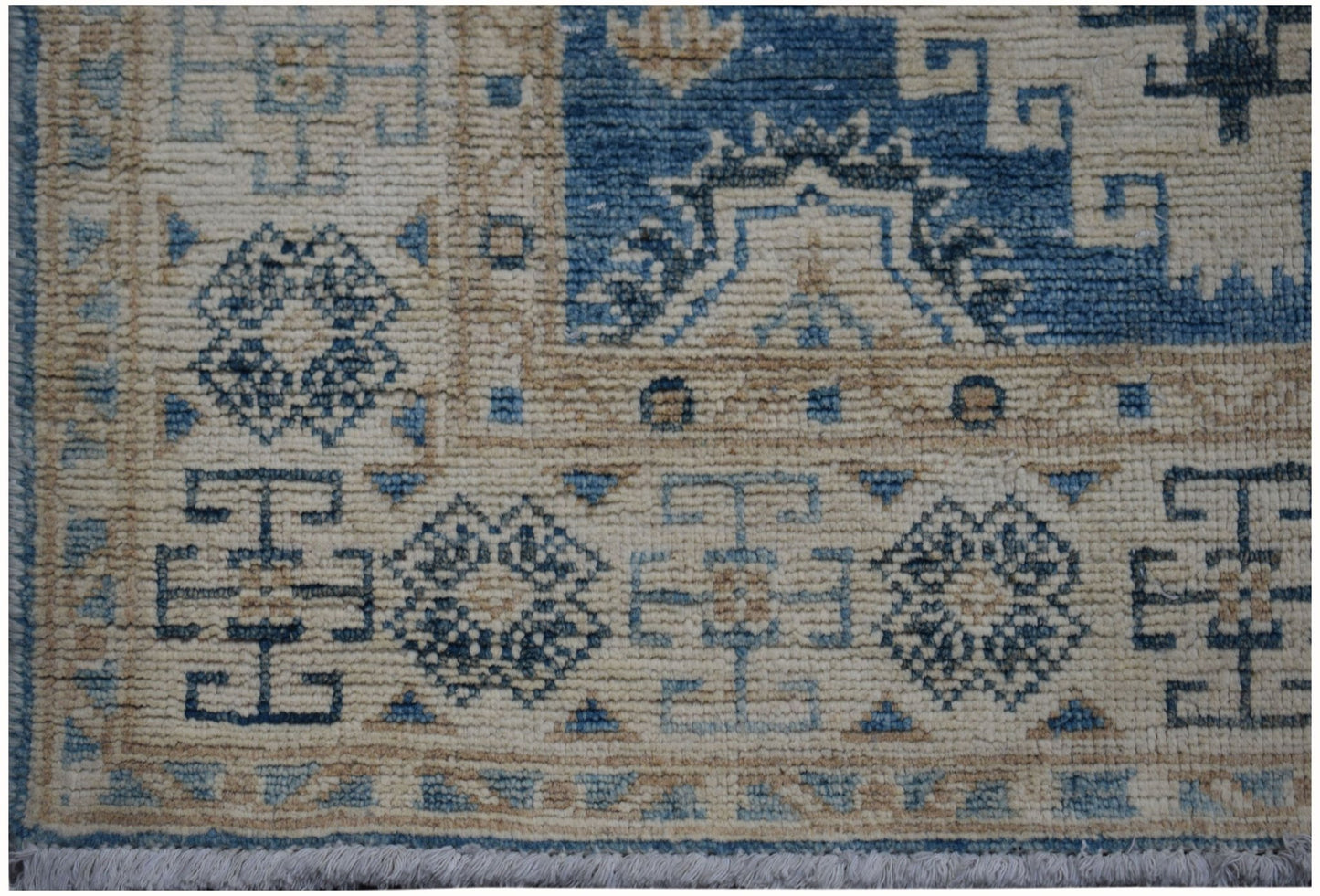 Handmade Afghan Kazakh runner rug featuring geometric patterns in shades of blue and beige.