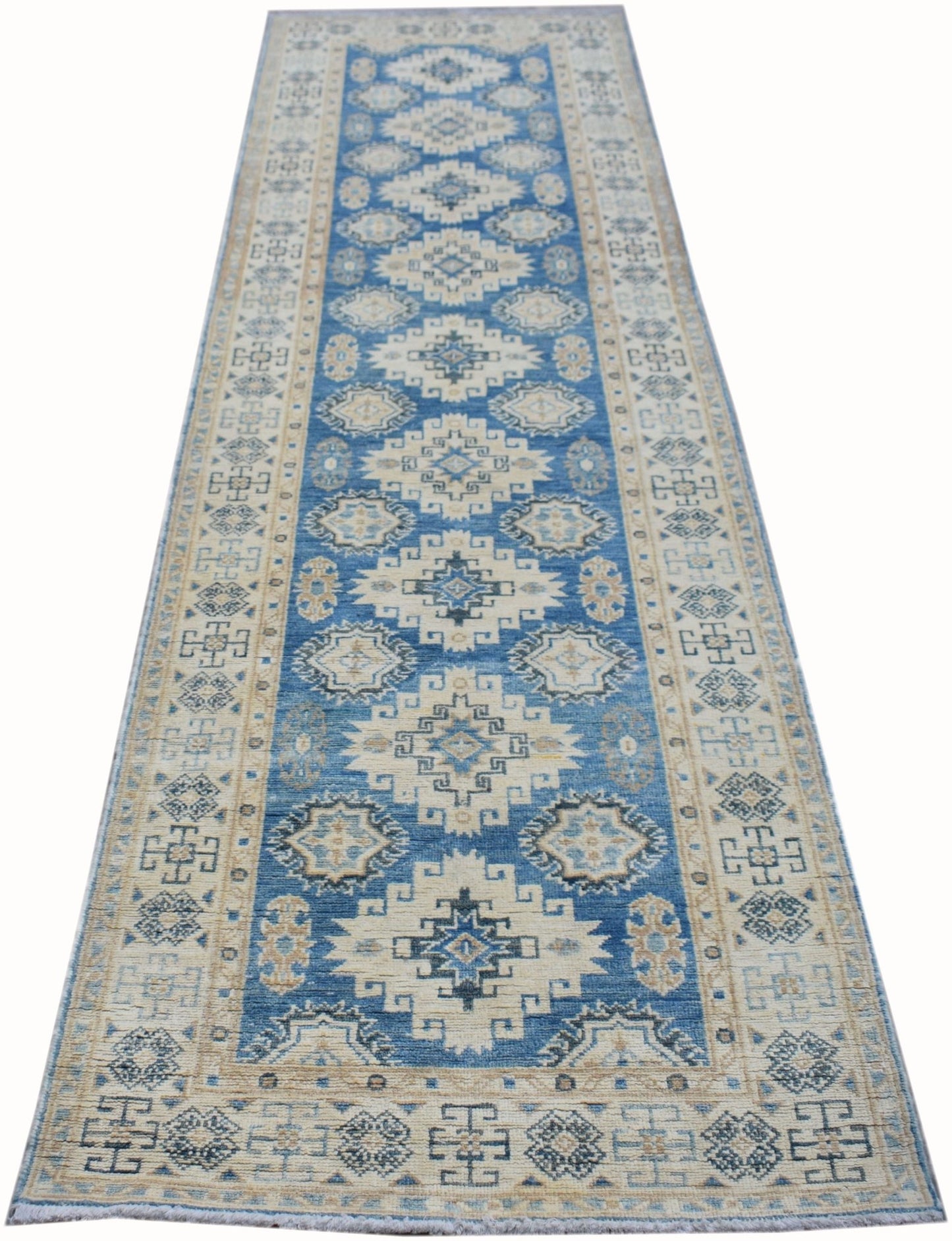 An Afghan Kazakh runner rug featuring a geometric pattern in shades of blue, beige, and grey.