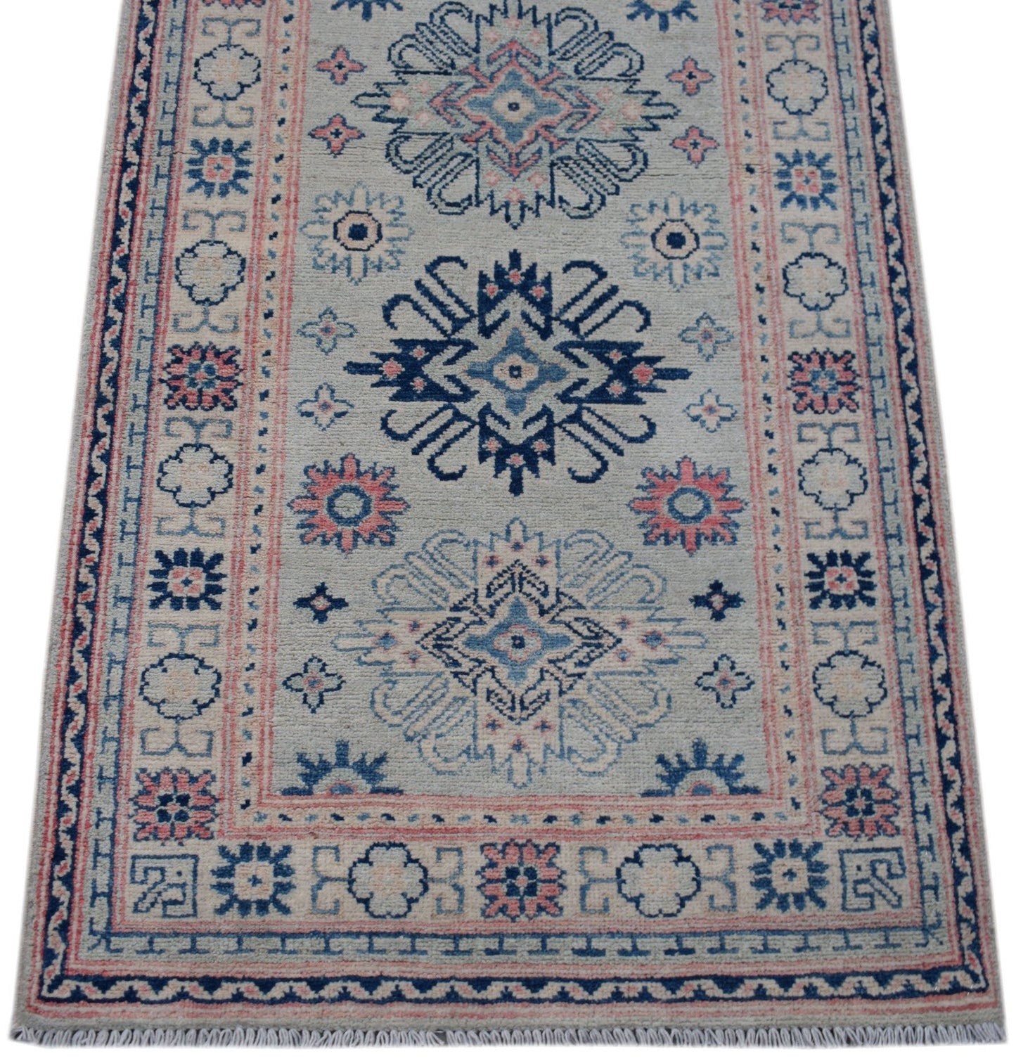 Handmade Afghan Kazakh runner rug featuring traditional geometric motifs in blue and pink.