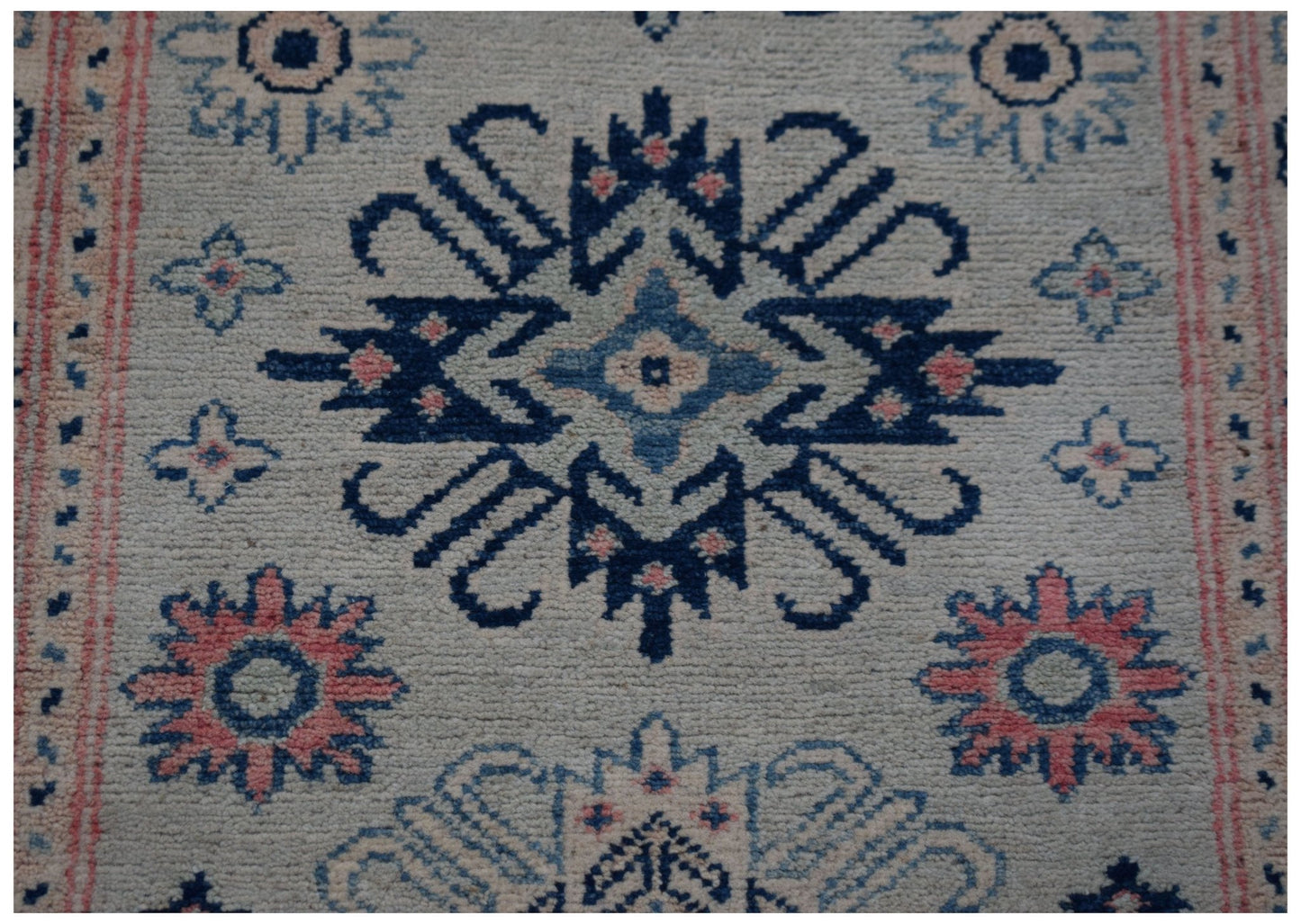 Handmade Afghan Kazakh runner rug featuring traditional blue and pink geometric floral motifs.