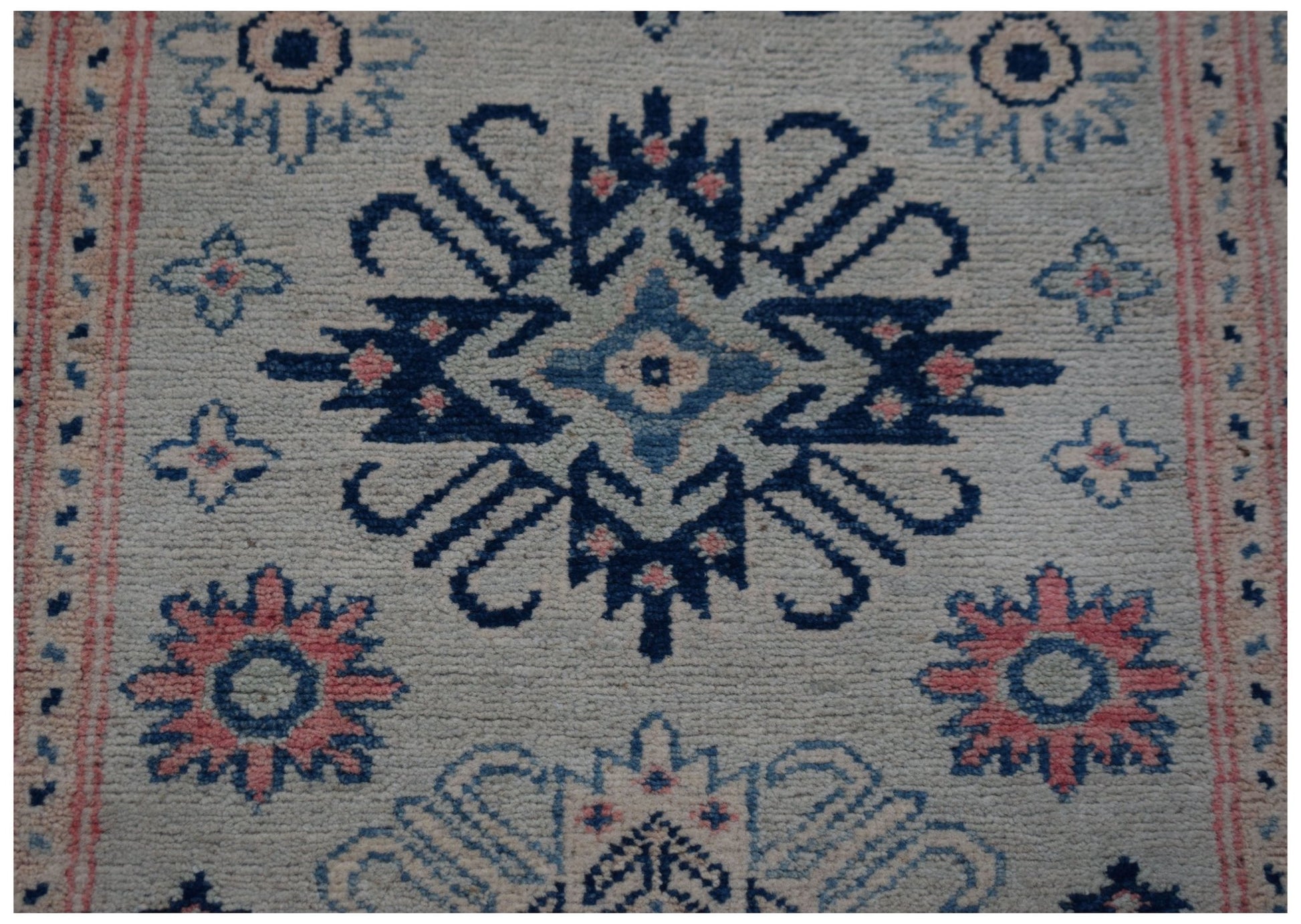 Handmade Afghan Kazakh runner rug featuring traditional blue and pink geometric floral motifs.