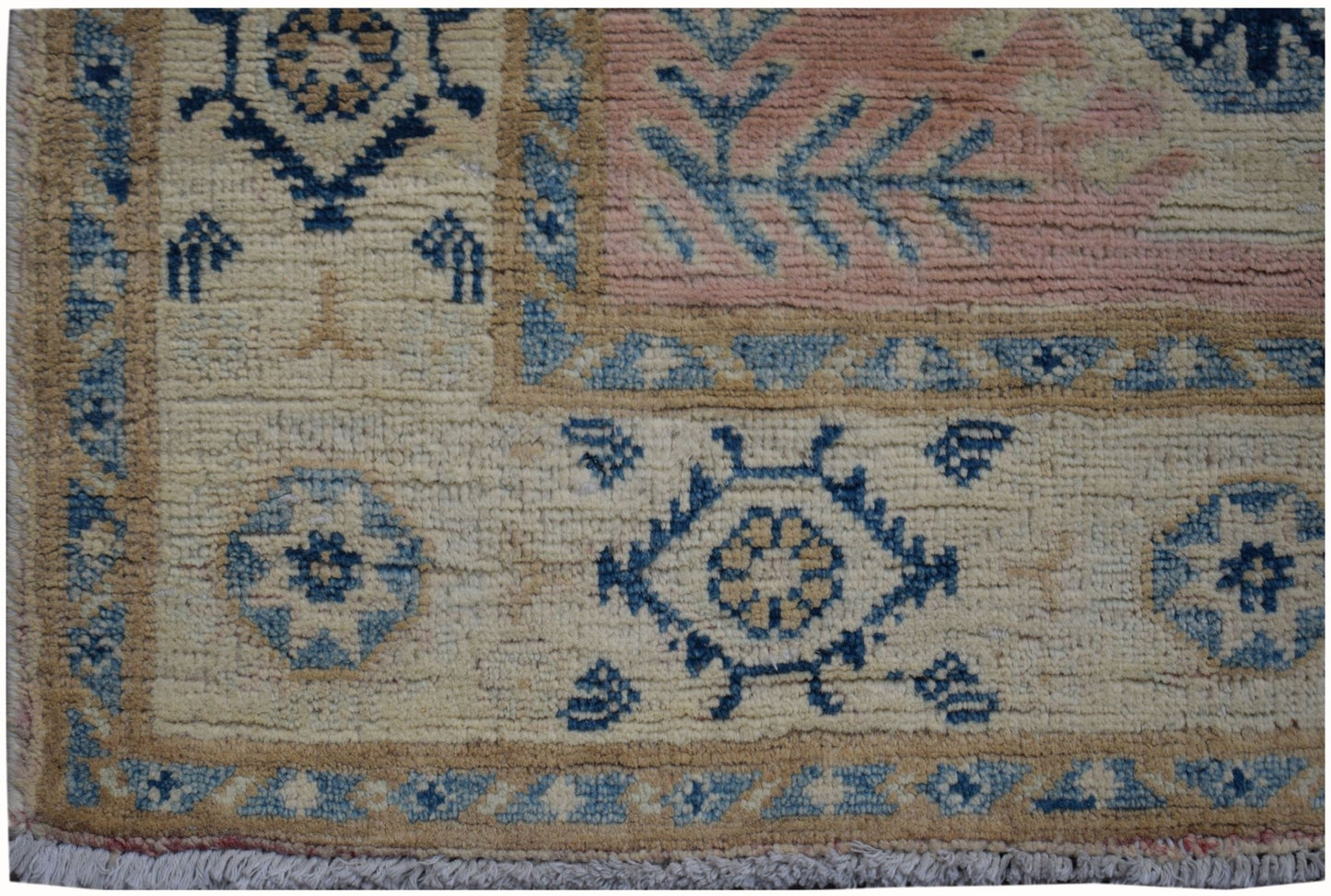 Handmade Afghan Kazakh runner featuring geometric blue and beige patterns on a wool pile.