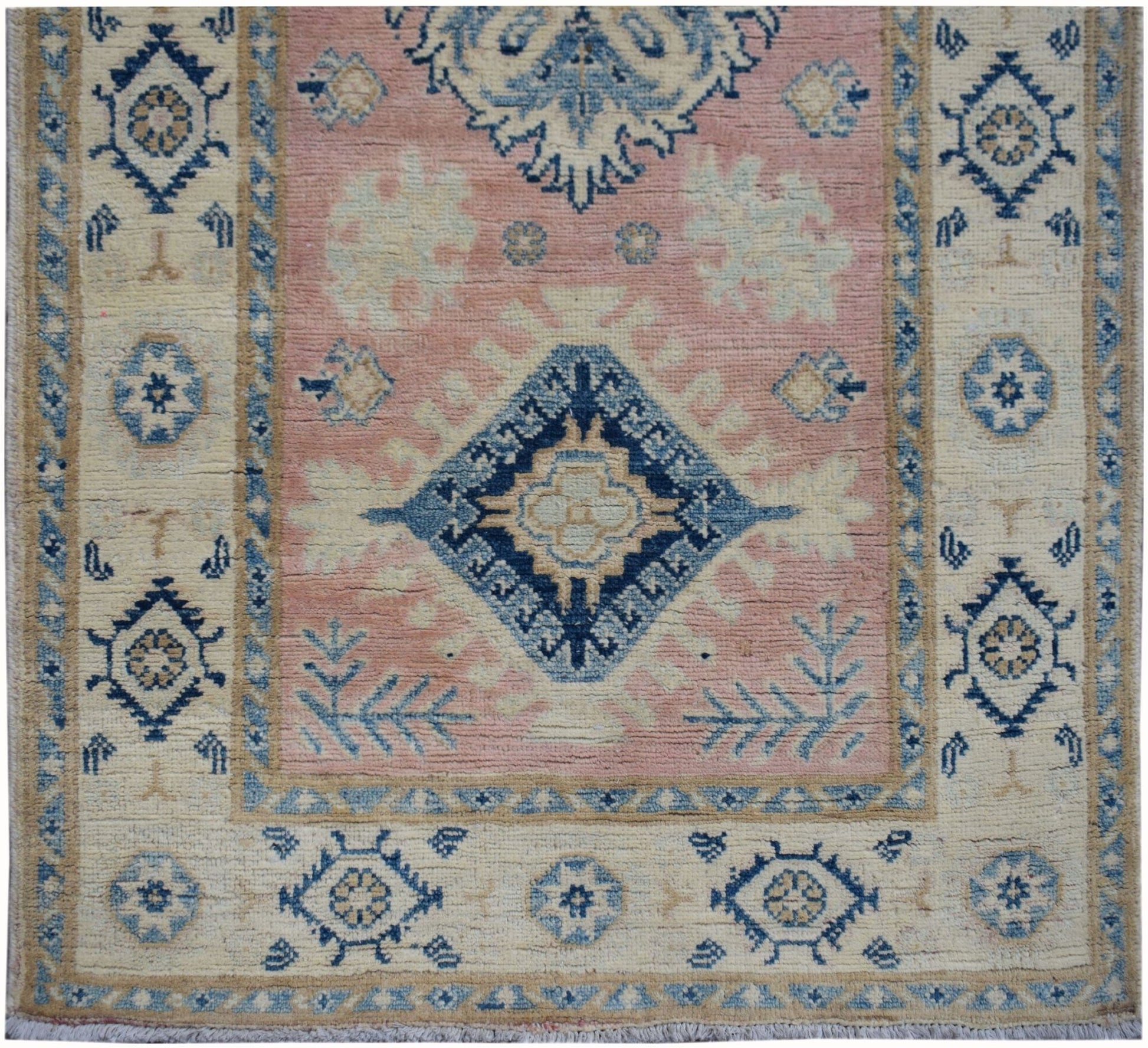 Handmade Afghan Kazakh runner featuring a central blue diamond motif on a soft pink field.
