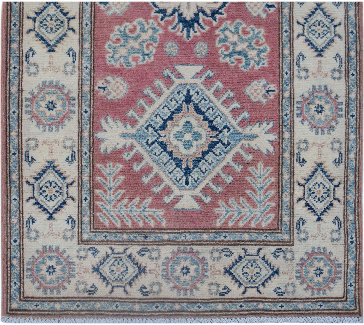 Handmade Afghan Kazakh runner featuring a central blue diamond motif on a dusty pink background.