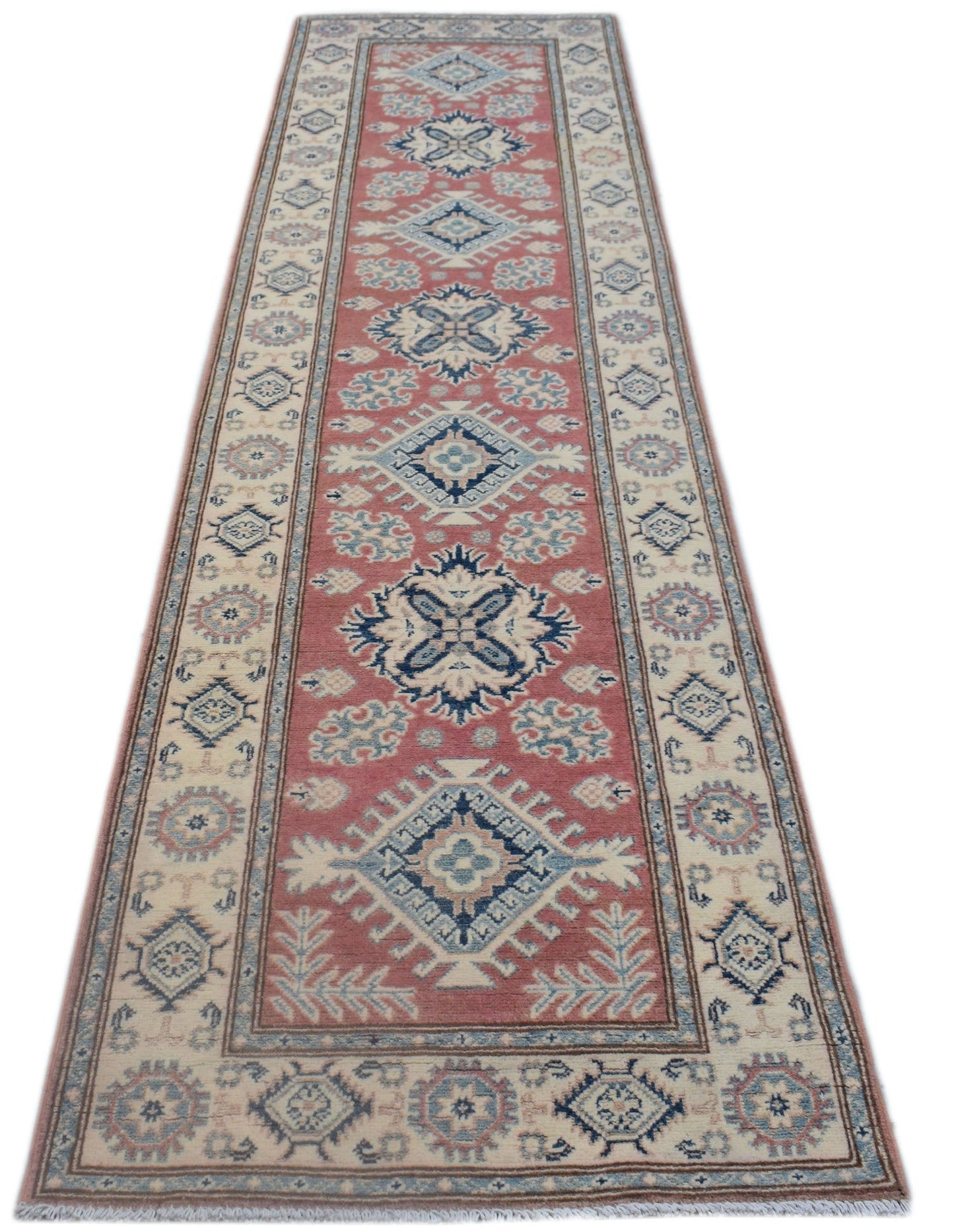 A handmade Afghan Kazakh runner rug featuring traditional geometric motifs in red, blue, and cream.