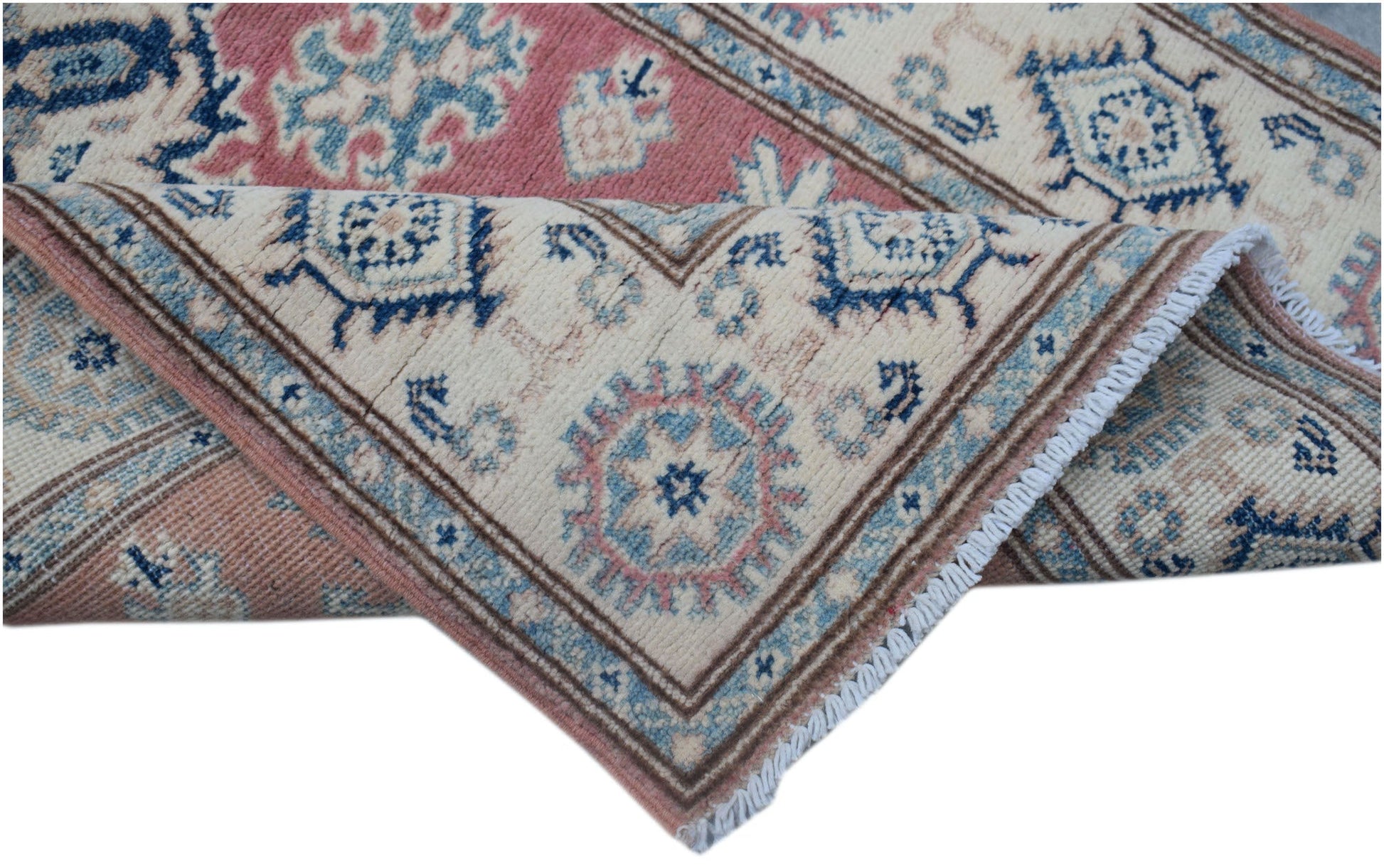 A handmade Afghan Kazakh runner featuring traditional geometric motifs in pink, blue, and cream.