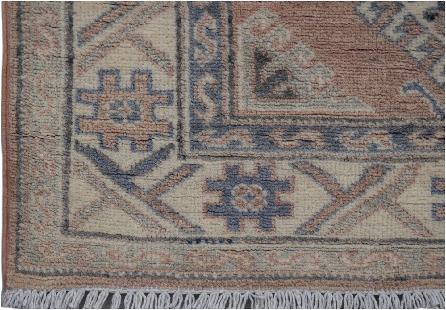A handmade Afghan Kazakh runner featuring traditional geometric motifs in muted blue and tan wool.