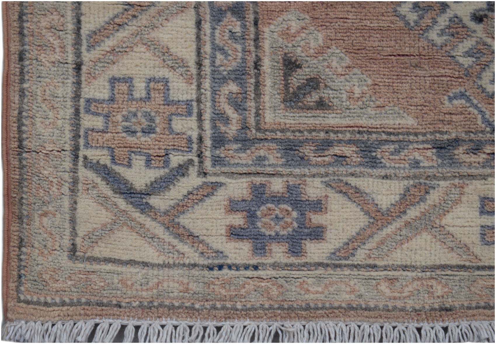A handmade Afghan Kazakh runner featuring traditional geometric motifs in muted blue and tan wool.