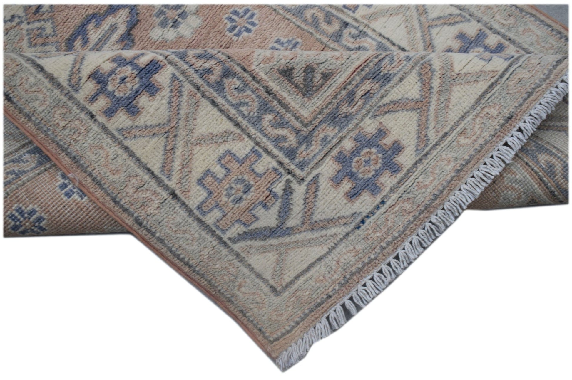 A handmade Afghan Kazakh runner featuring traditional geometric motifs in blue and beige wool.