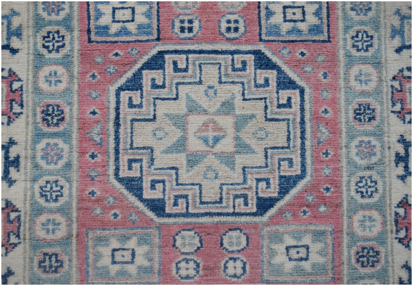 Handmade Afghan Kazakh runner featuring a geometric central medallion in blue, pink, and cream.