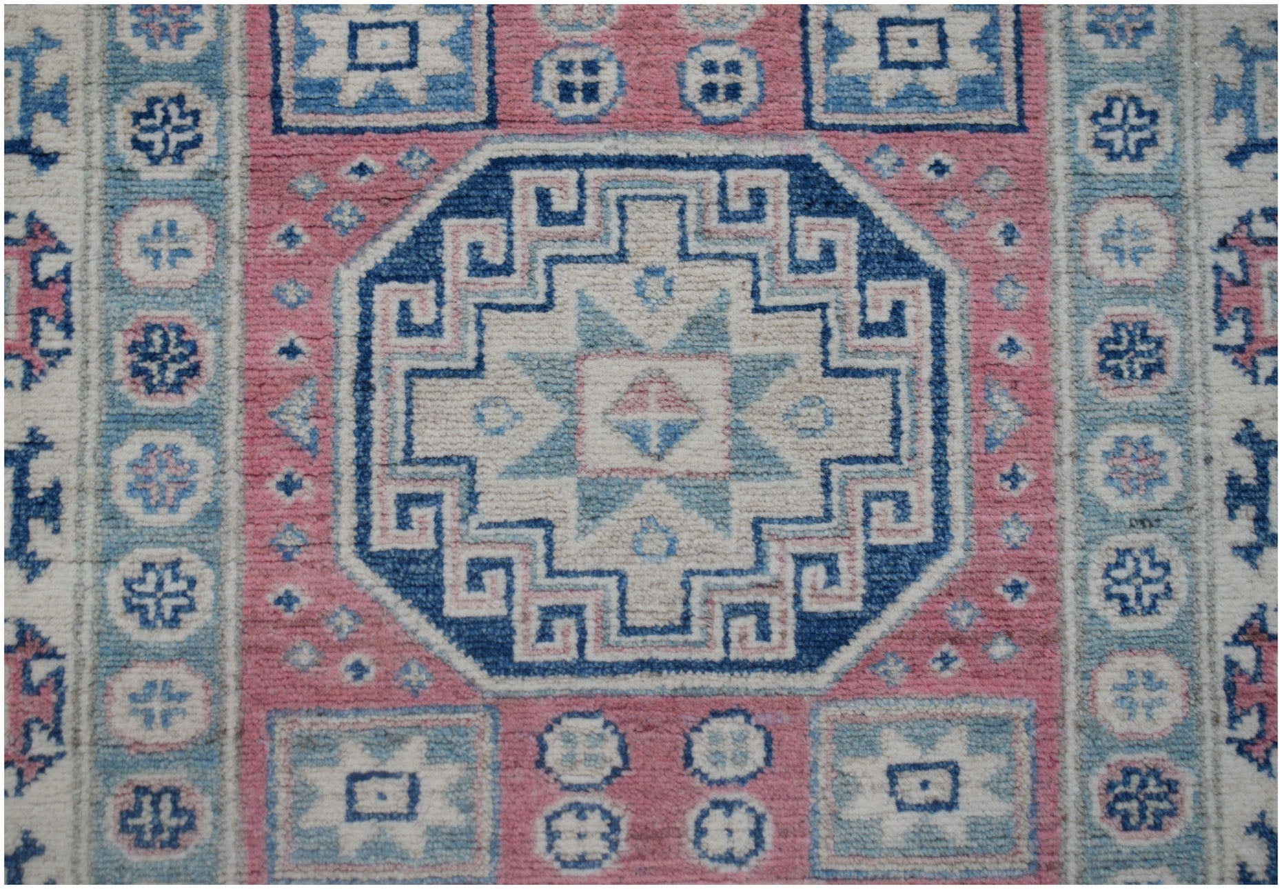Handmade Afghan Kazakh runner featuring a geometric central medallion in blue, pink, and cream.