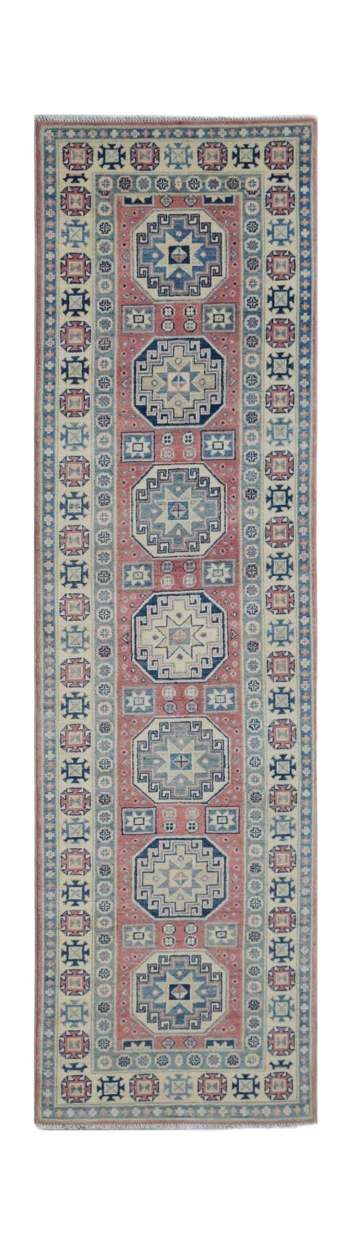 Handmade Afghan Kazakh runner rug featuring geometric medallions on a pink field.