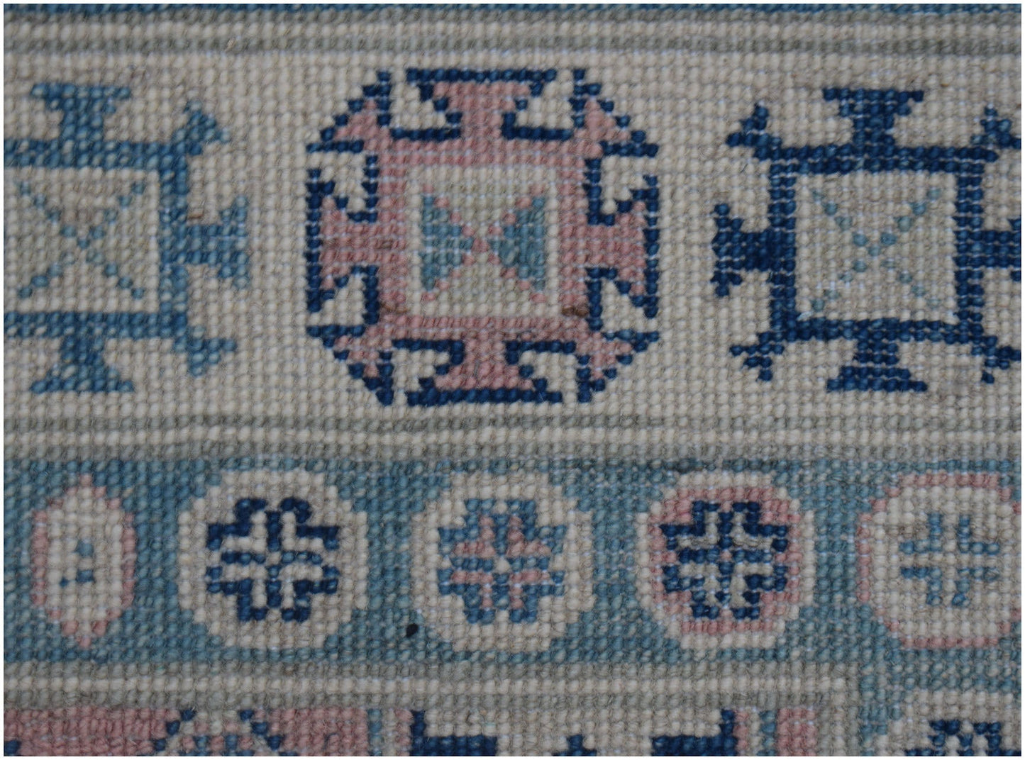 Handmade Afghan Kazakh runner featuring traditional geometric motifs in blue and pink wool.