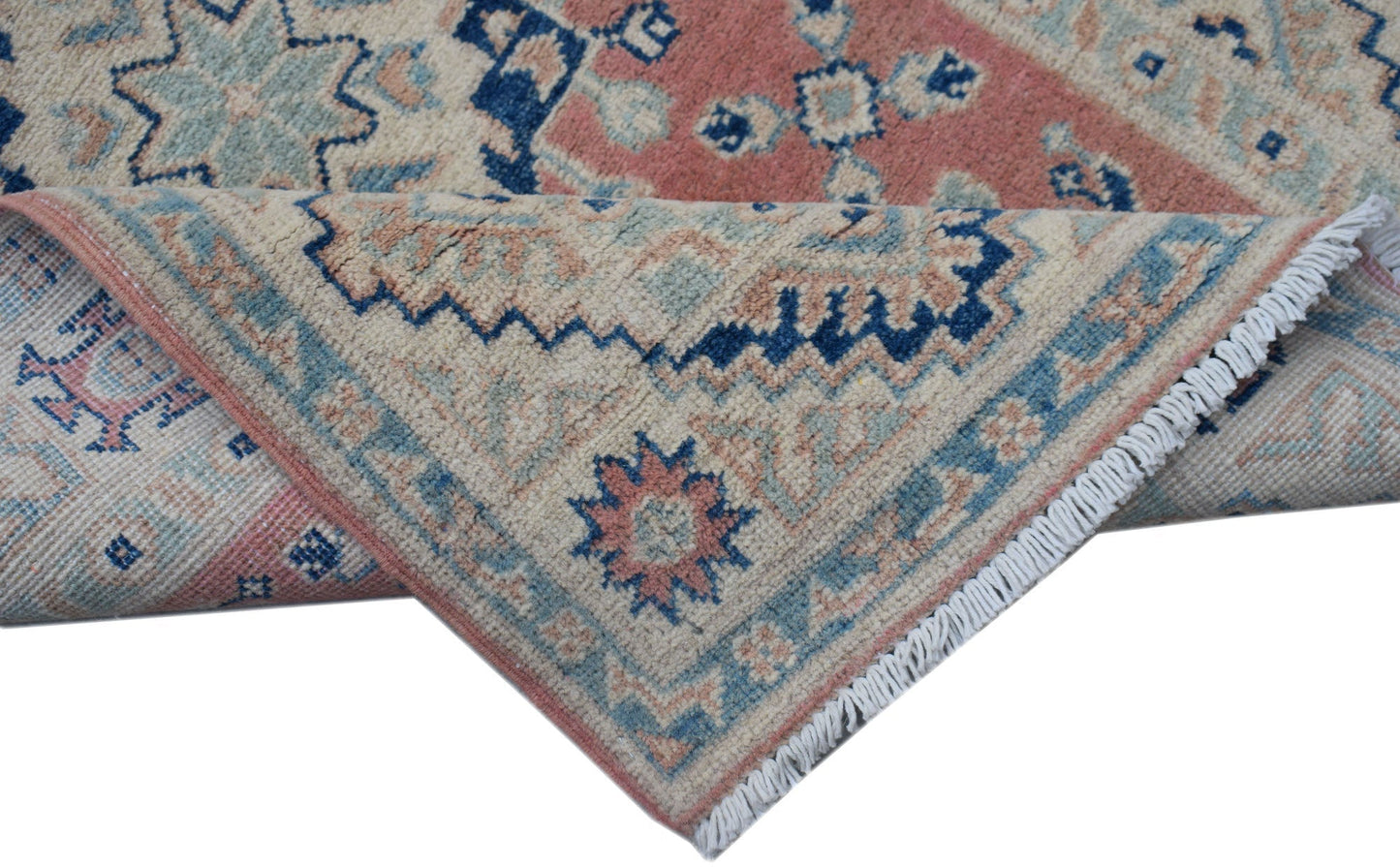 A handmade Afghan Kazakh runner featuring traditional geometric motifs in blue, pink, and cream.