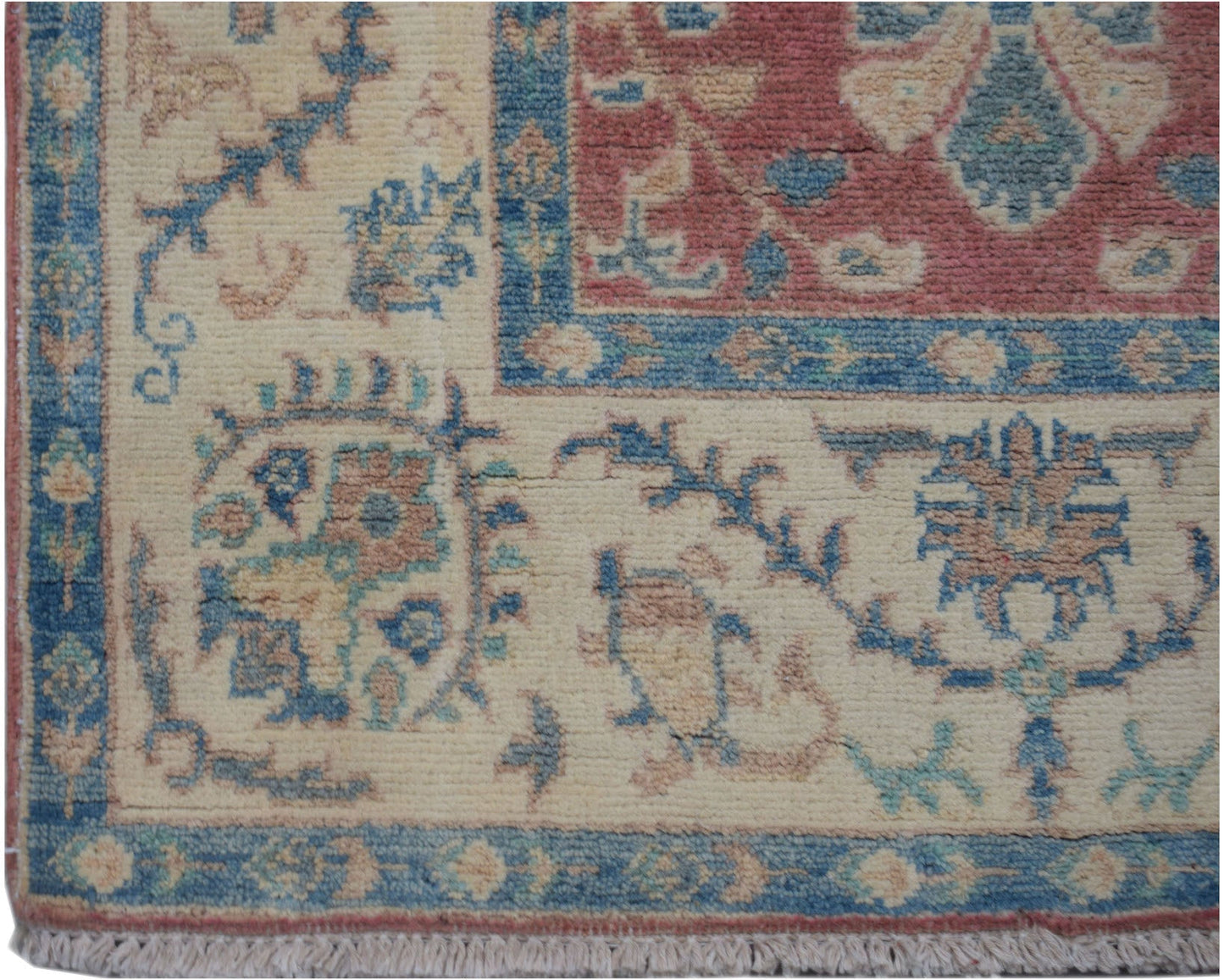 A handmade Afghan Kazakh runner featuring traditional floral motifs in blue, red, and cream wool.