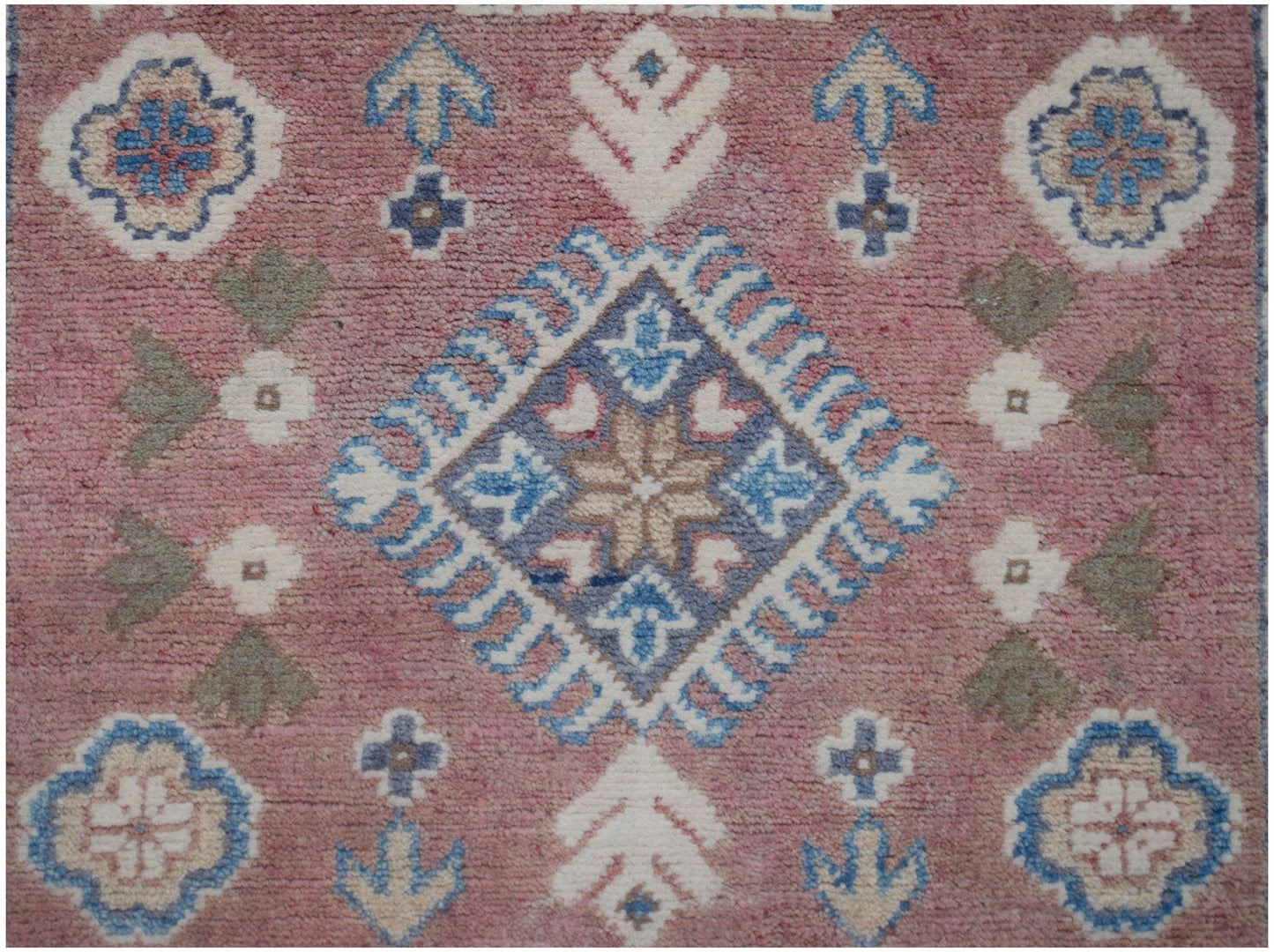 Handmade Afghan Kazakh runner featuring a pink field with traditional blue and white geometric motifs.