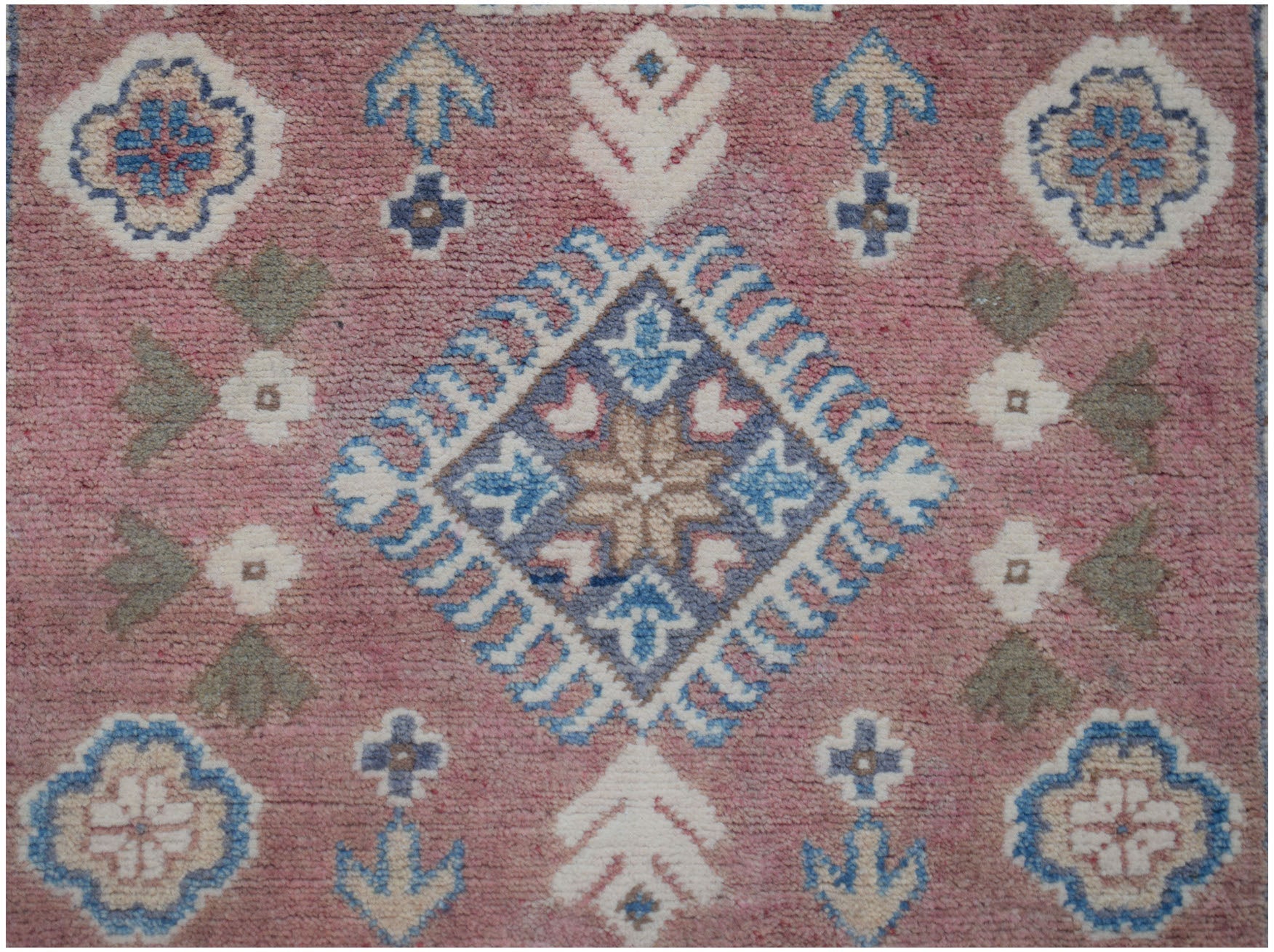 Handmade Afghan Kazakh runner featuring a pink field with traditional blue and white geometric motifs.