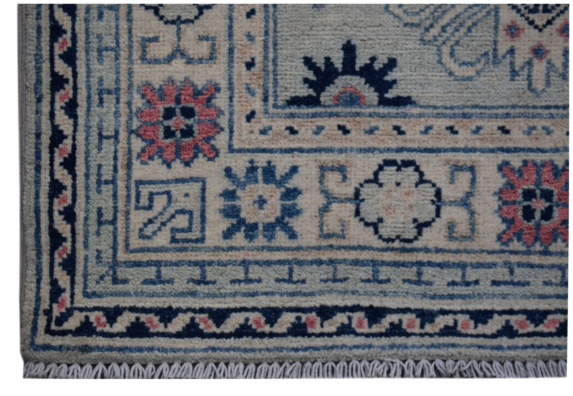A handmade Afghan Kazakh runner featuring traditional geometric motifs in blue, pink, and cream.