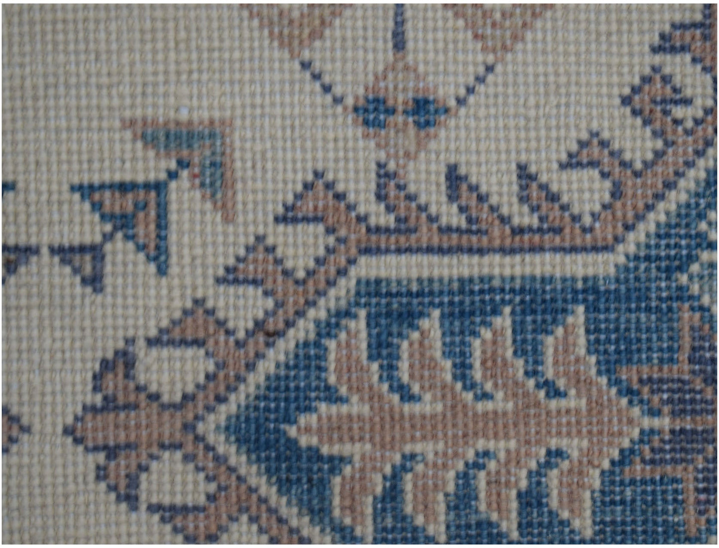 A close-up of an Afghan Kazakh runner featuring traditional geometric motifs in blue and tan wool.