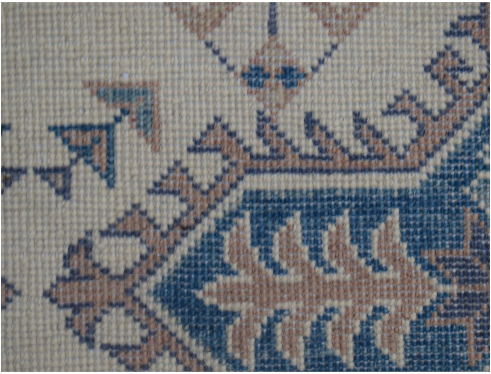 A close-up of an Afghan Kazakh runner featuring traditional geometric motifs in blue and tan wool.