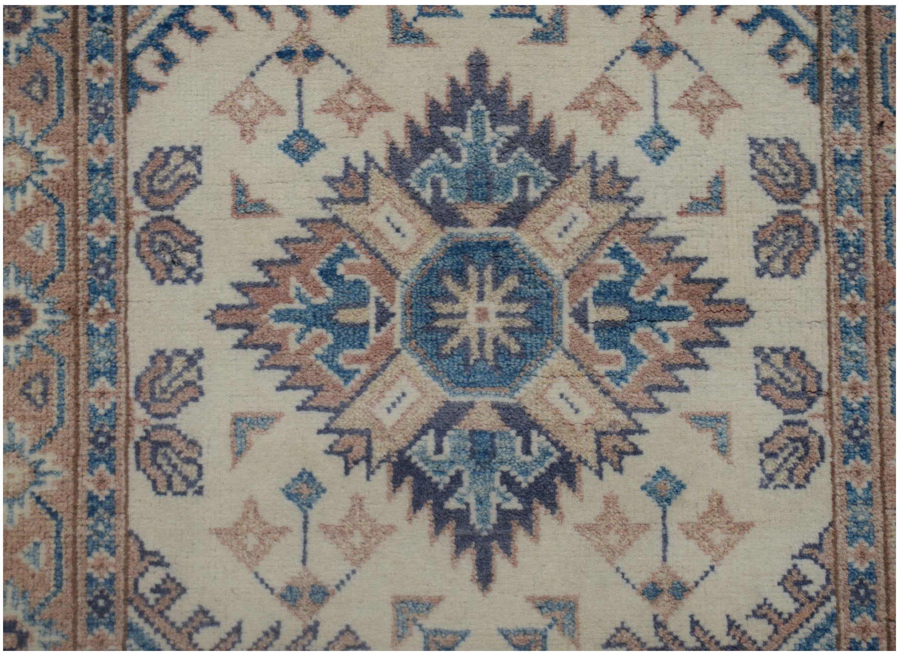 An Afghan Kazakh runner featuring a central geometric medallion in blue and tan on a cream field.