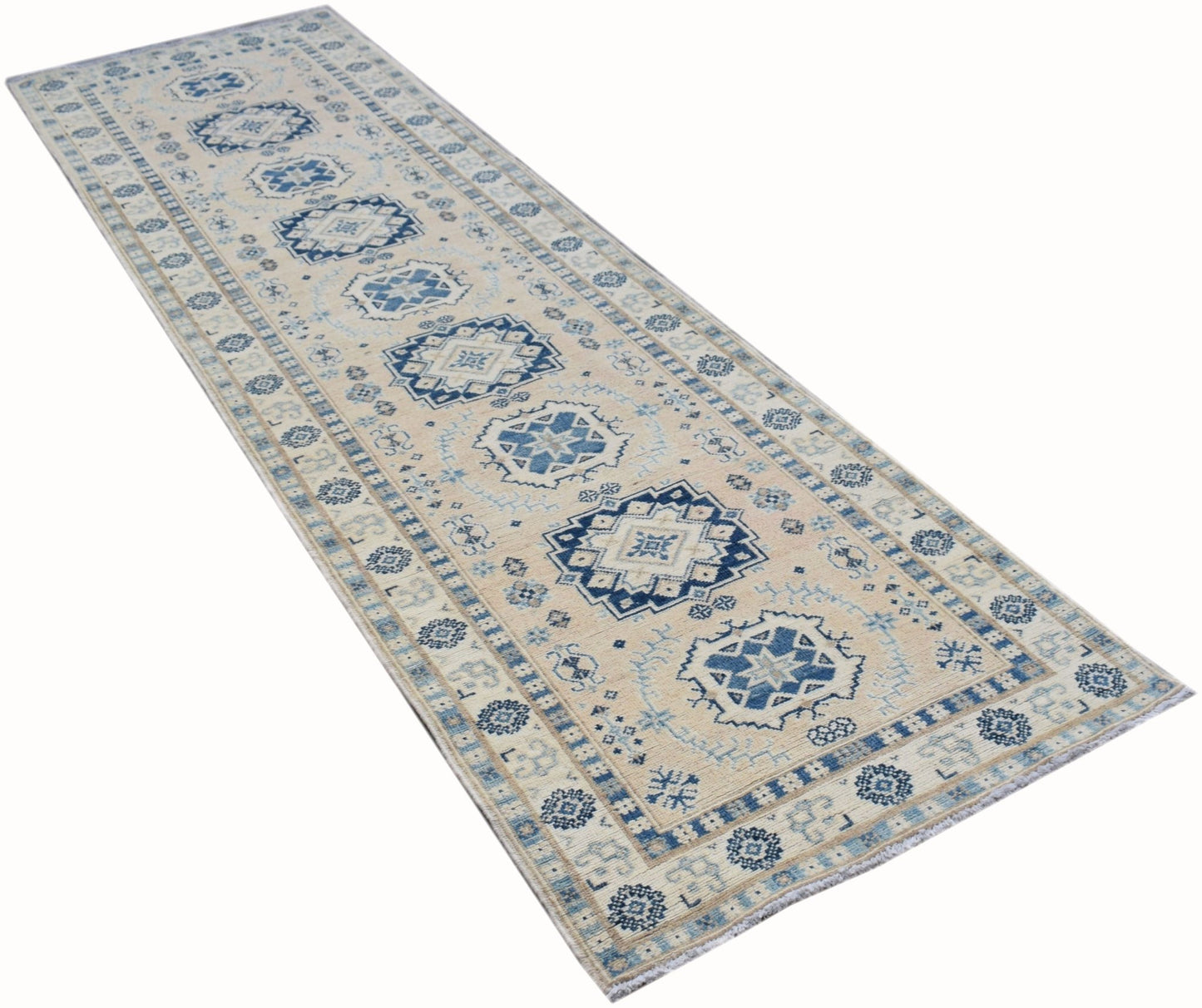 A handmade Afghan Kazakh runner rug featuring traditional blue geometric motifs on a beige field.