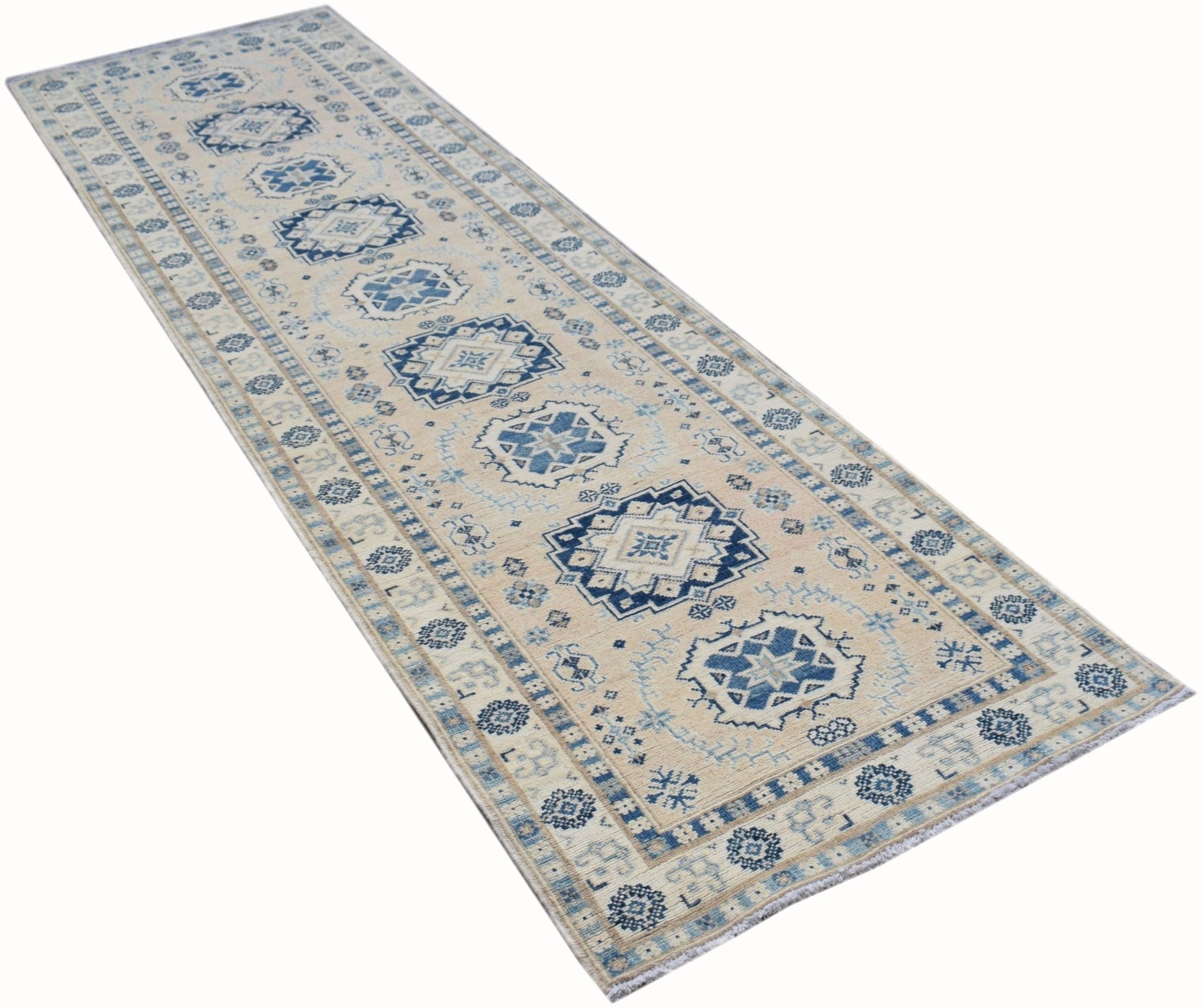 A handmade Afghan Kazakh runner rug featuring traditional blue geometric motifs on a beige field.