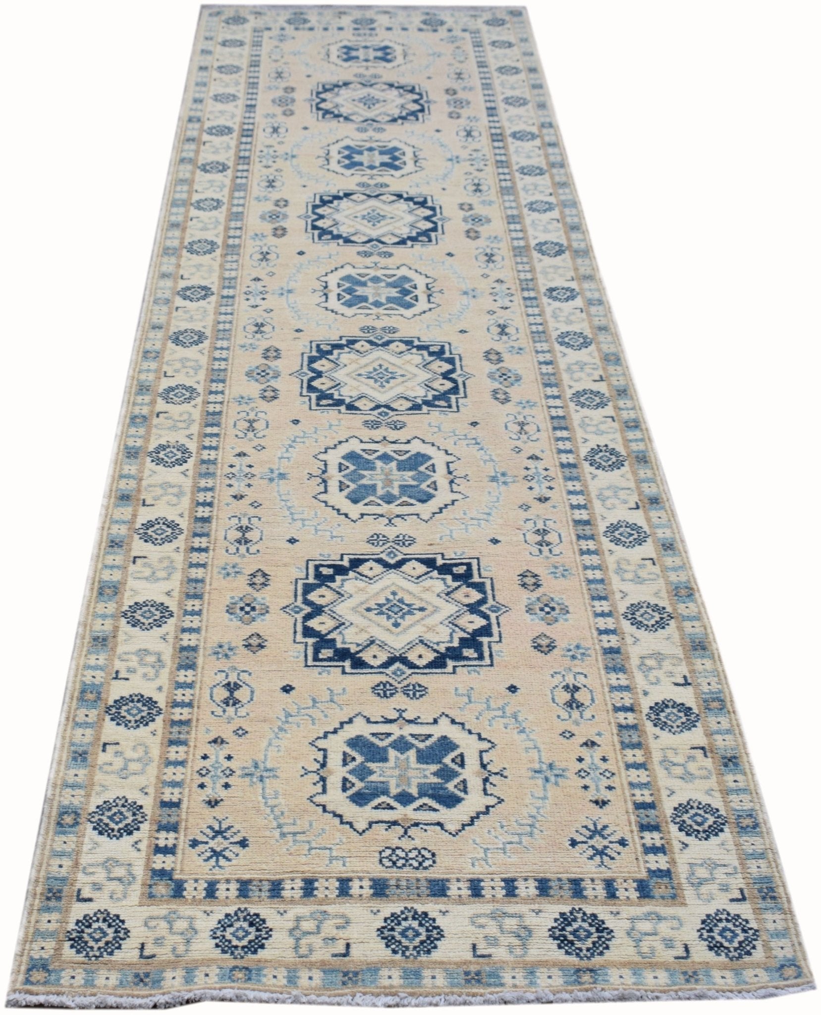Handmade Afghan Kazakh runner rug featuring geometric blue patterns on a beige wool background.