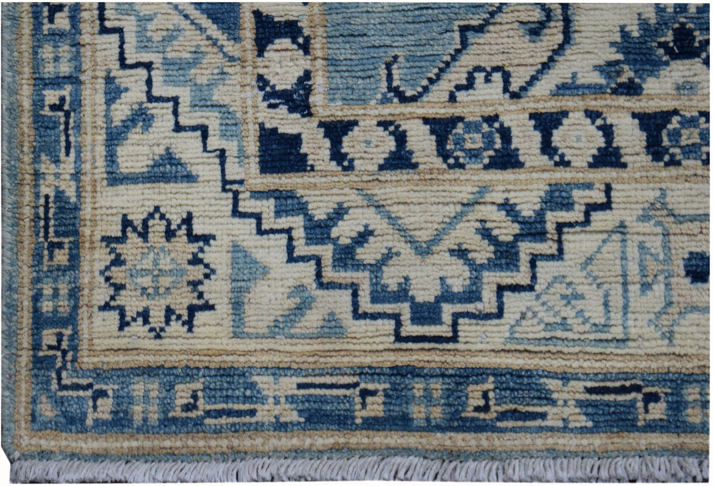 Handmade Afghan Kazakh runner rug featuring a geometric blue and beige pattern with fringe.
