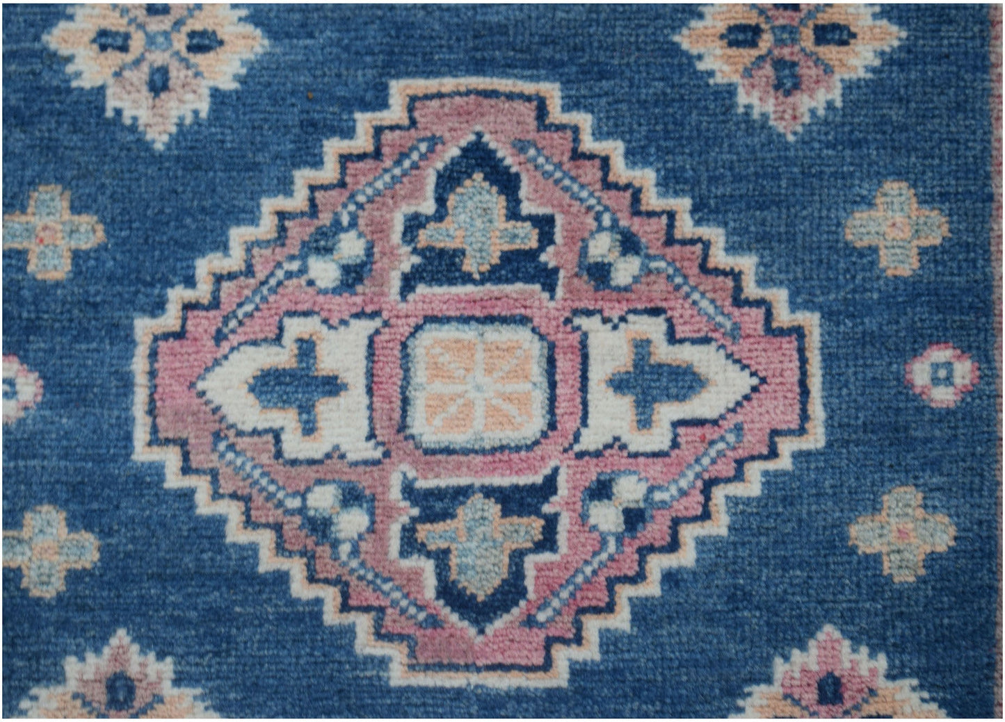 Handmade Afghan Kazakh runner rug featuring a central geometric medallion on a blue background.
