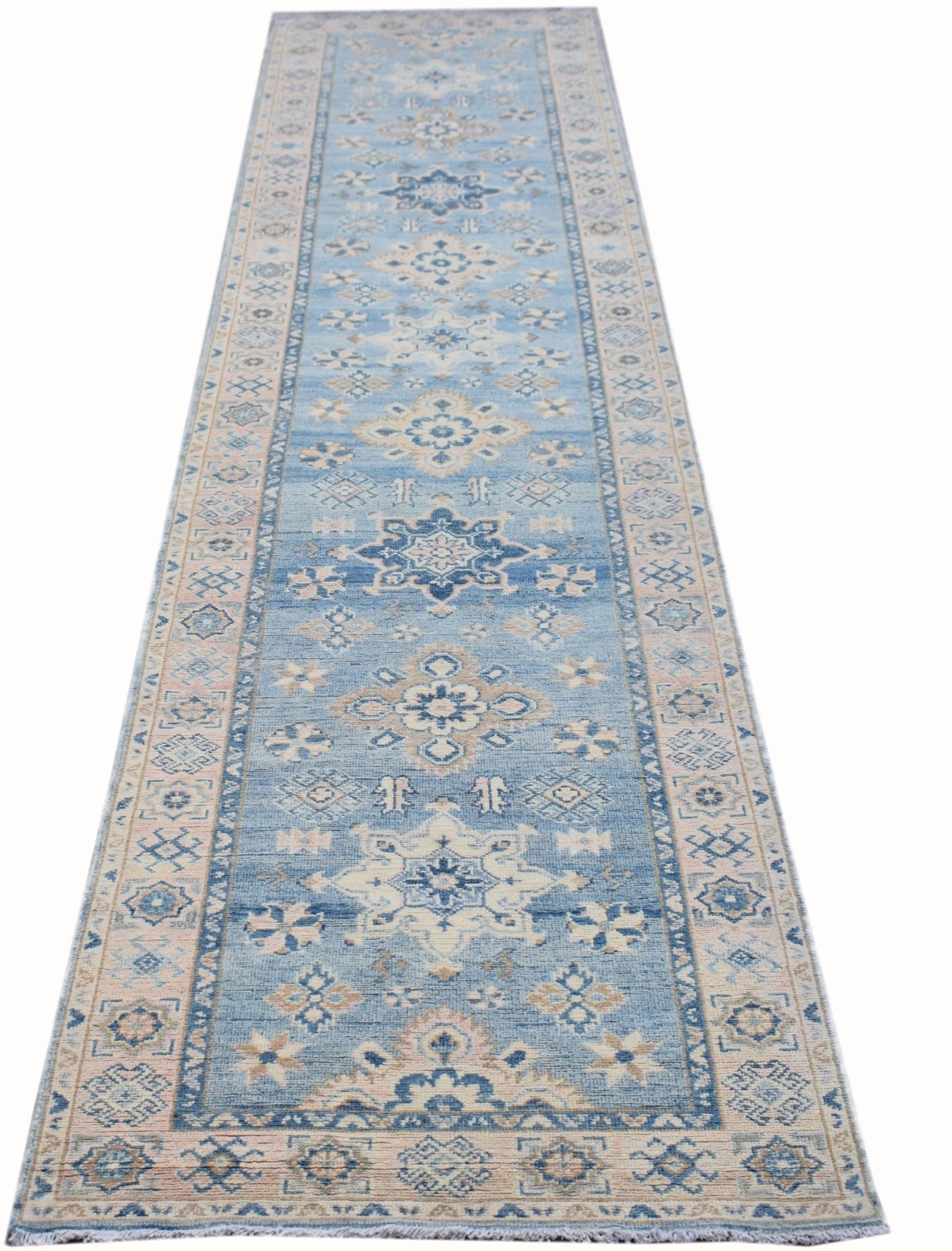 A handmade Afghan Kazakh runner rug featuring traditional geometric patterns in blue and beige.