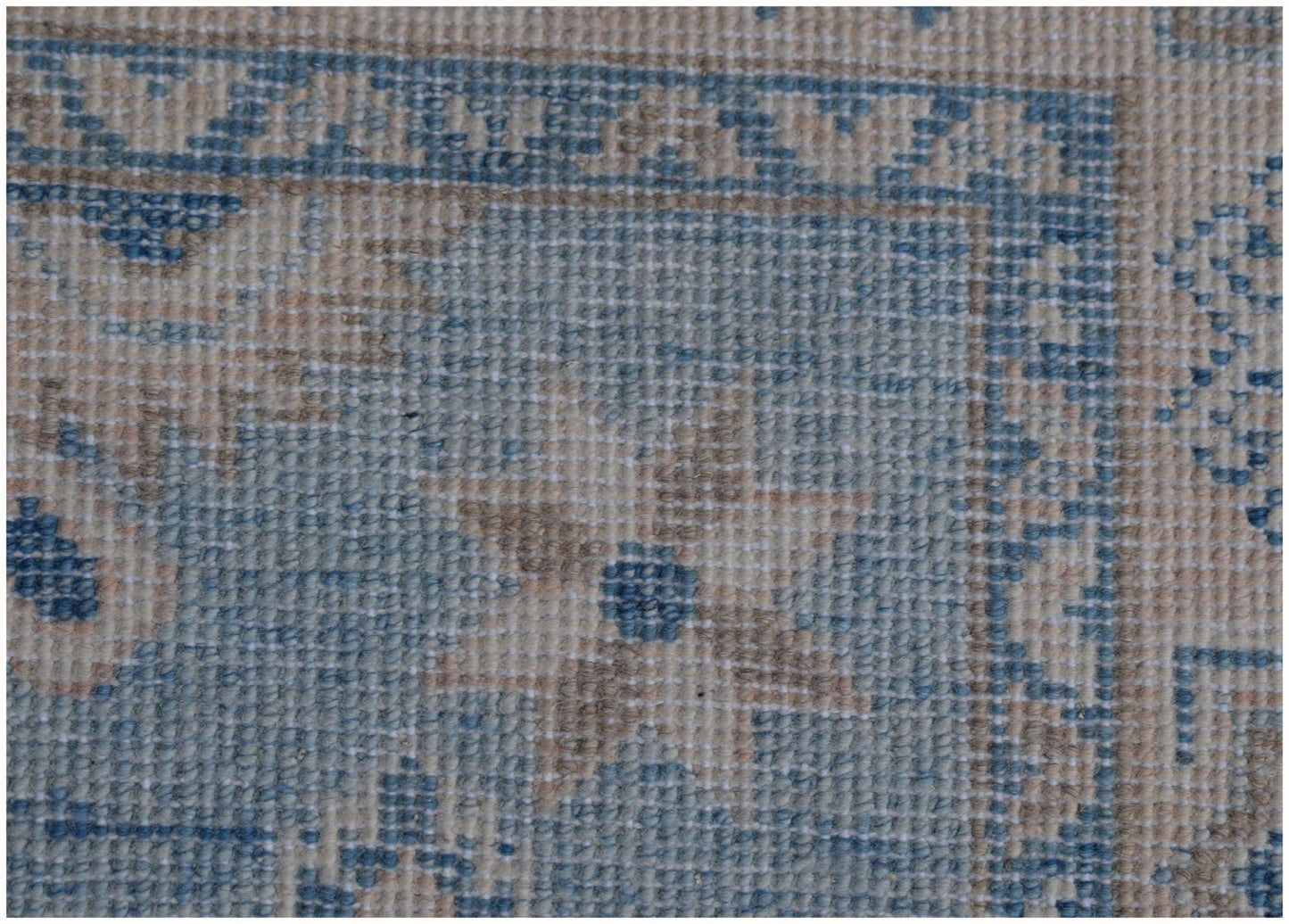 A handmade Afghan Kazakh runner featuring traditional patterns in shades of blue and beige.