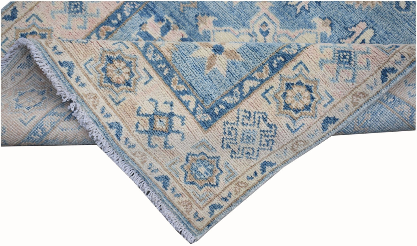 A handmade Afghan Kazakh runner featuring traditional geometric patterns in blue and cream wool.