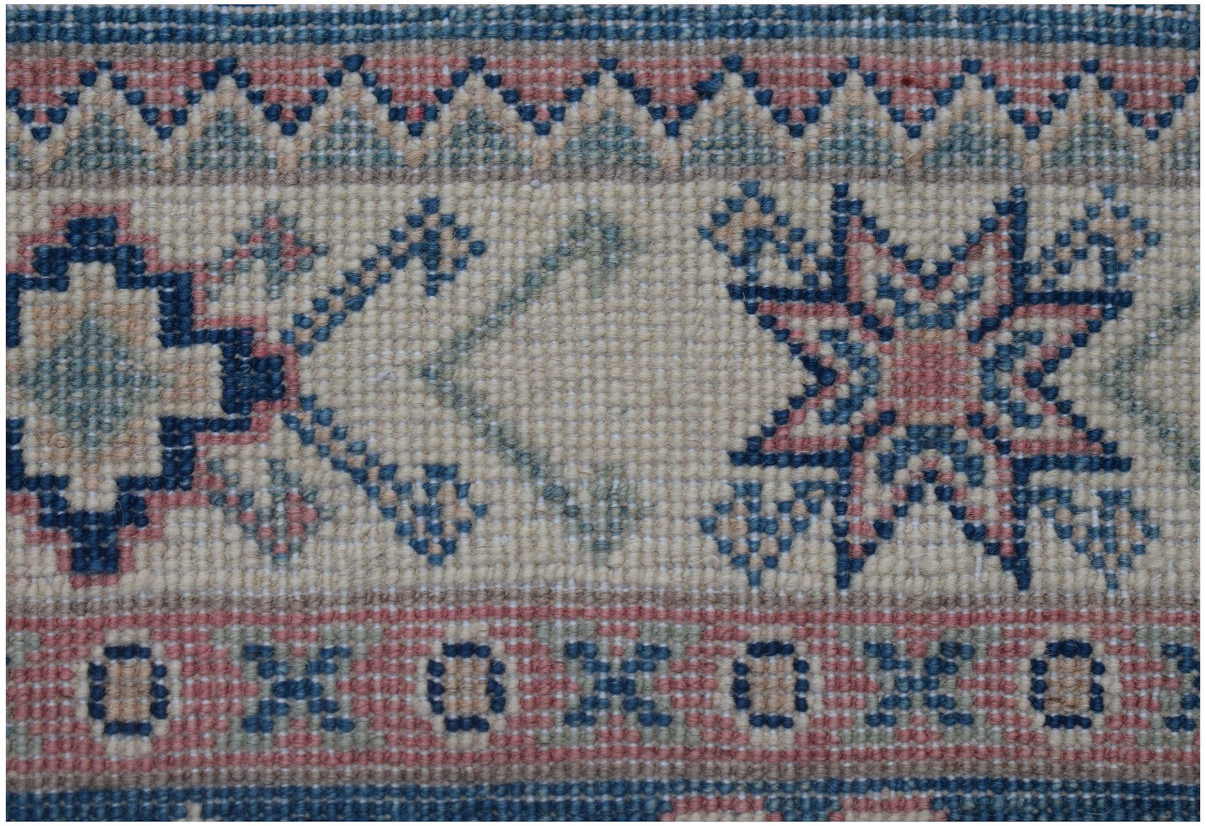 A close-up of an Afghan Kazakh runner featuring traditional geometric star and border motifs.