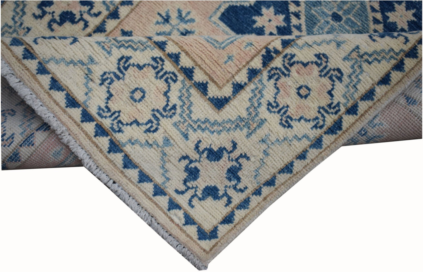 A handmade Afghan Kazakh runner featuring a geometric pattern in blue and beige wool.