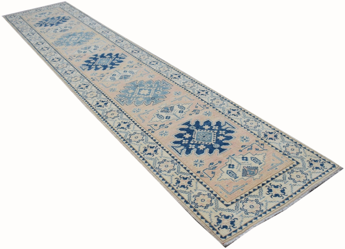 Handmade Afghan Kazakh runner rug featuring a geometric blue pattern on a beige wool background.