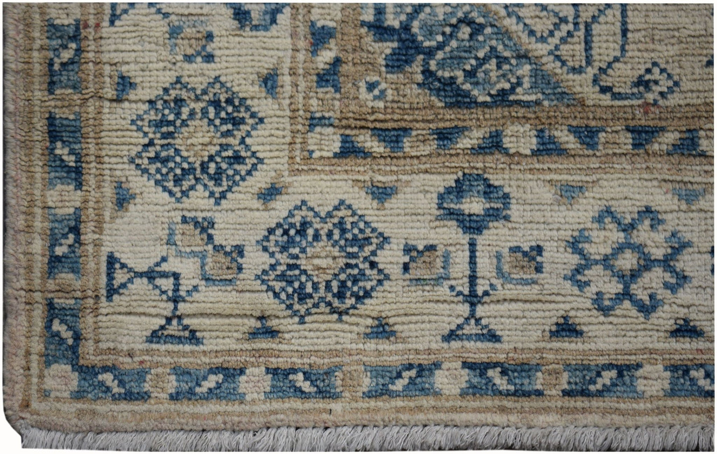 A handmade Afghan Kazakh runner rug featuring a beige field with blue geometric floral patterns.