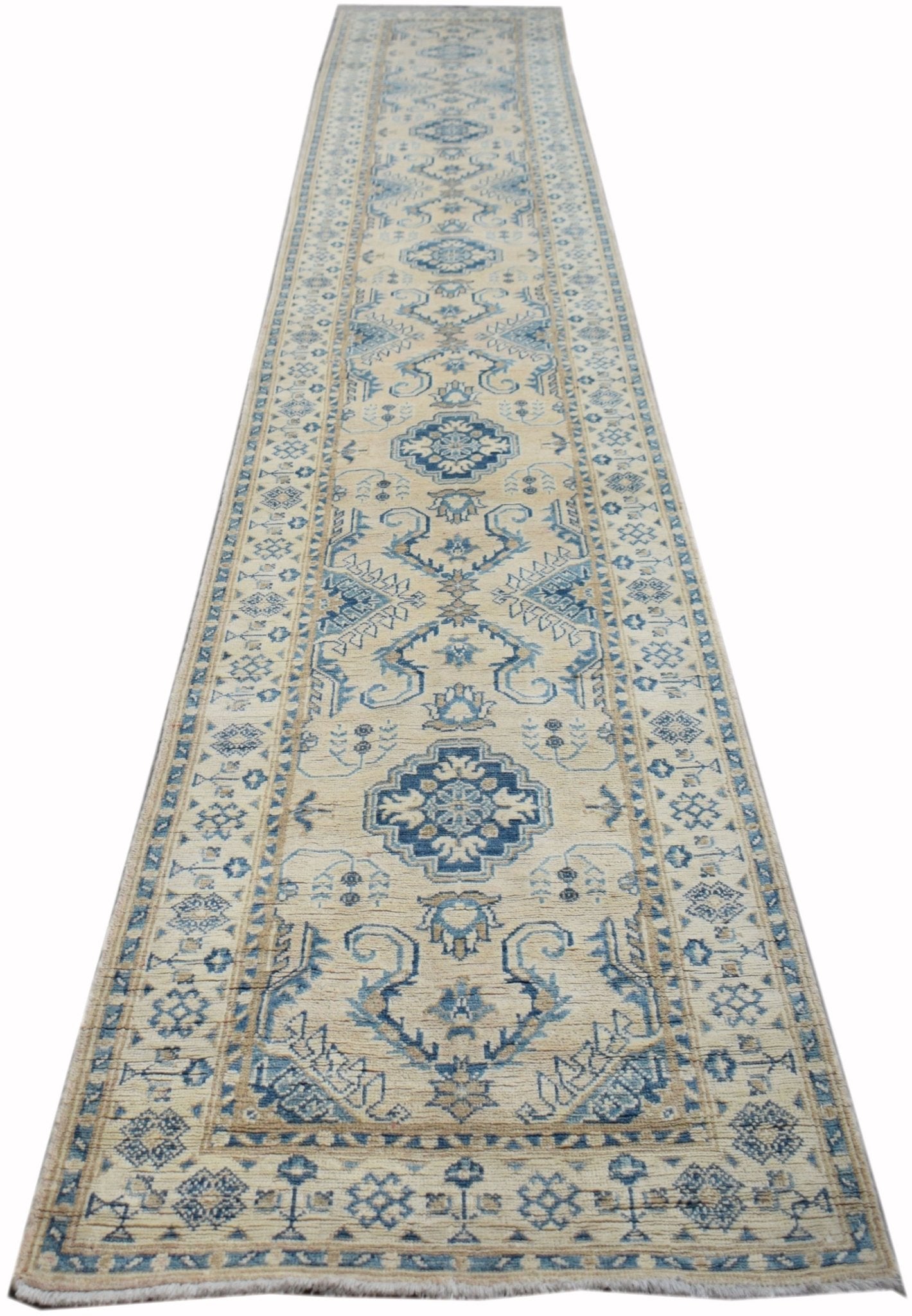 A handmade Afghan Kazakh runner rug featuring a traditional blue and beige geometric pattern.