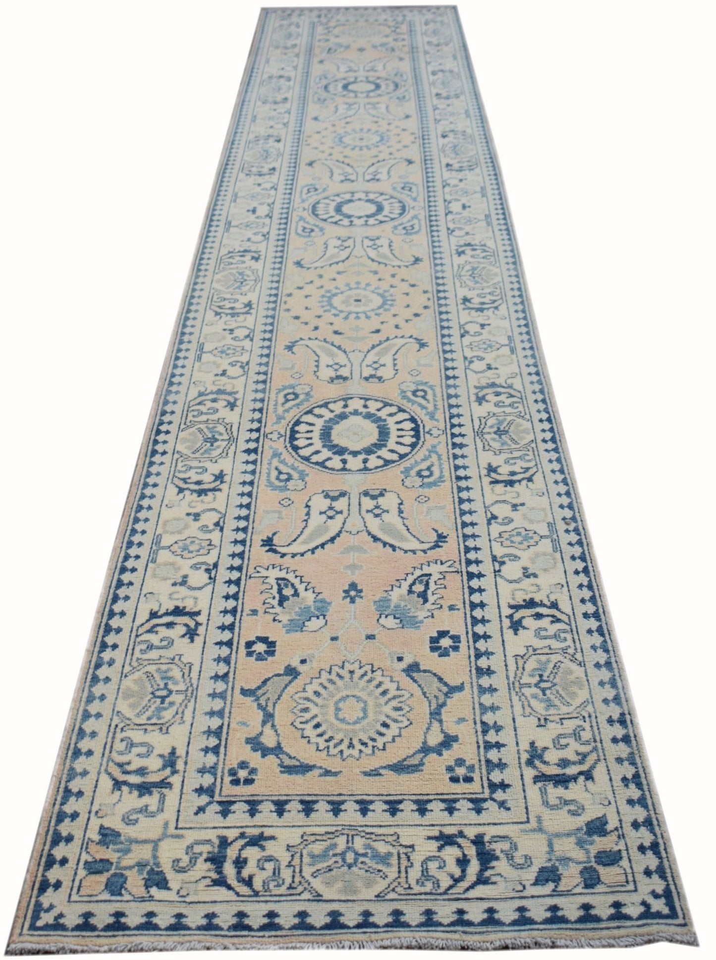 An Afghan Kazakh runner rug featuring a traditional blue and beige geometric floral pattern.